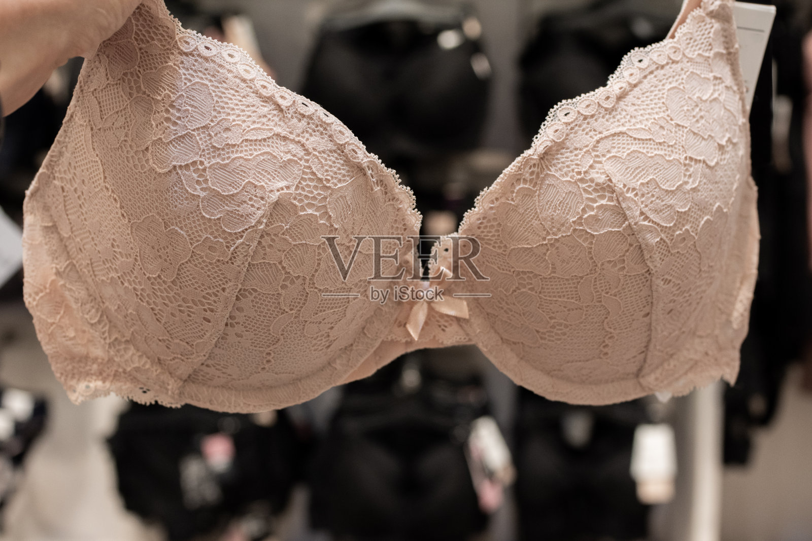 米色文胸，保持女性乳房健康，乳腺癌意识。在商店挑选胸罩照片摄影图片