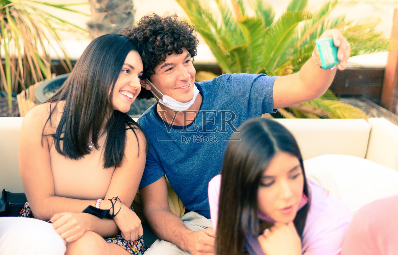 一对夫妇戴着口罩自拍保护冠状病毒-年轻的朋友们玩口罩-新的正常生活理念照片摄影图片