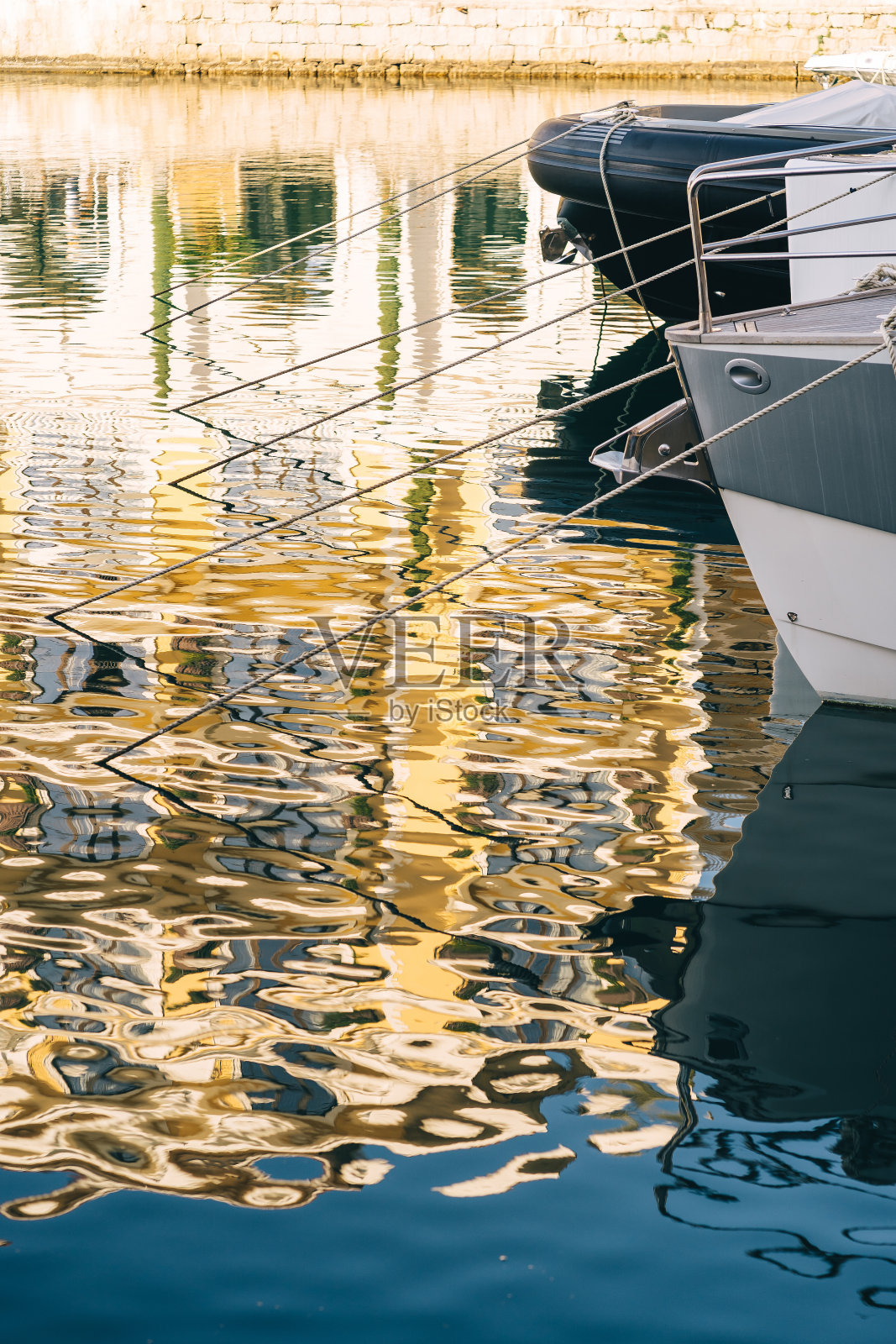 游艇俱乐部里停泊的游艇将阳光反射在水面上照片摄影图片