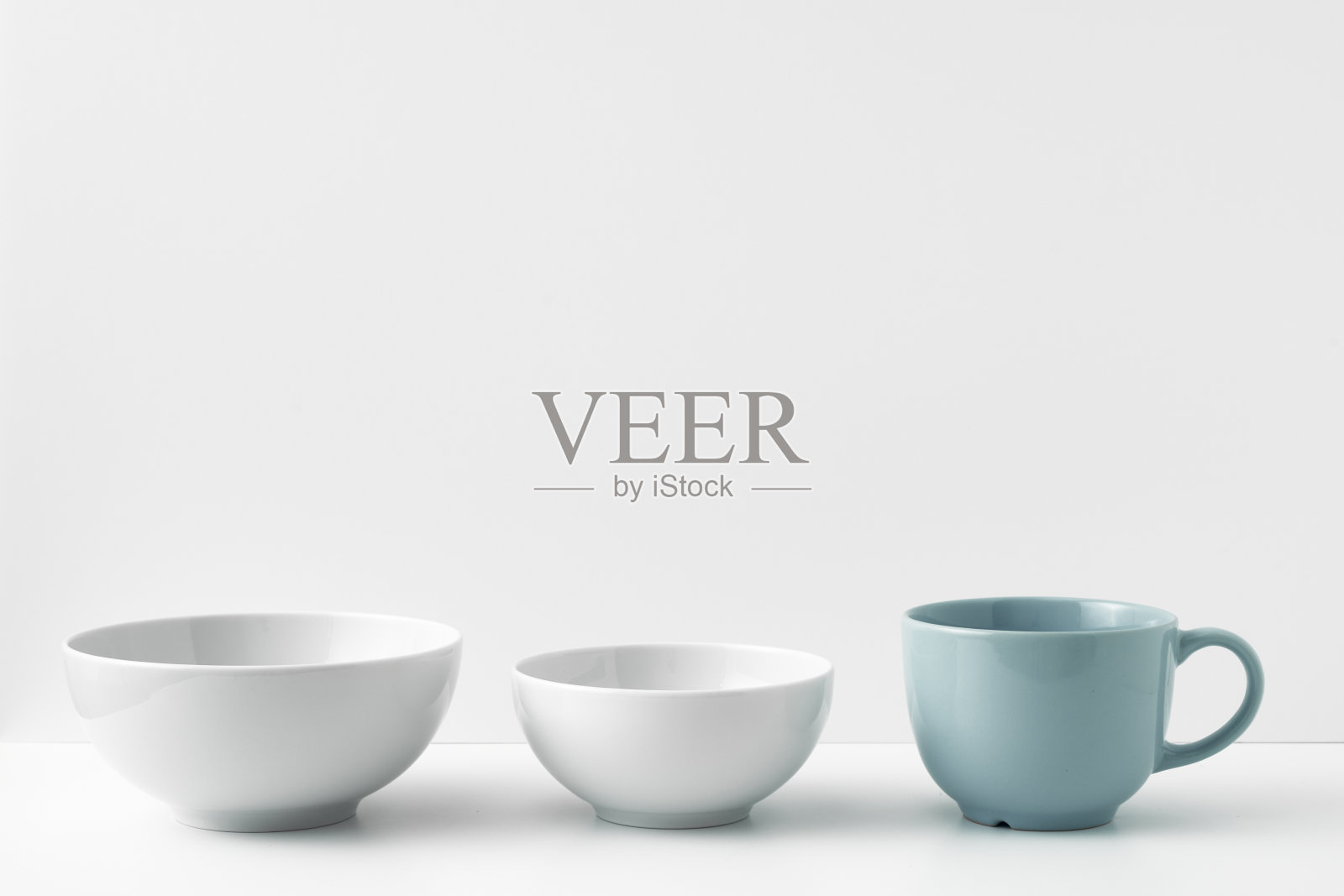 三个圆圈站在一个白色的表面上，背景是白色的。复制空间，模拟。照片摄影图片