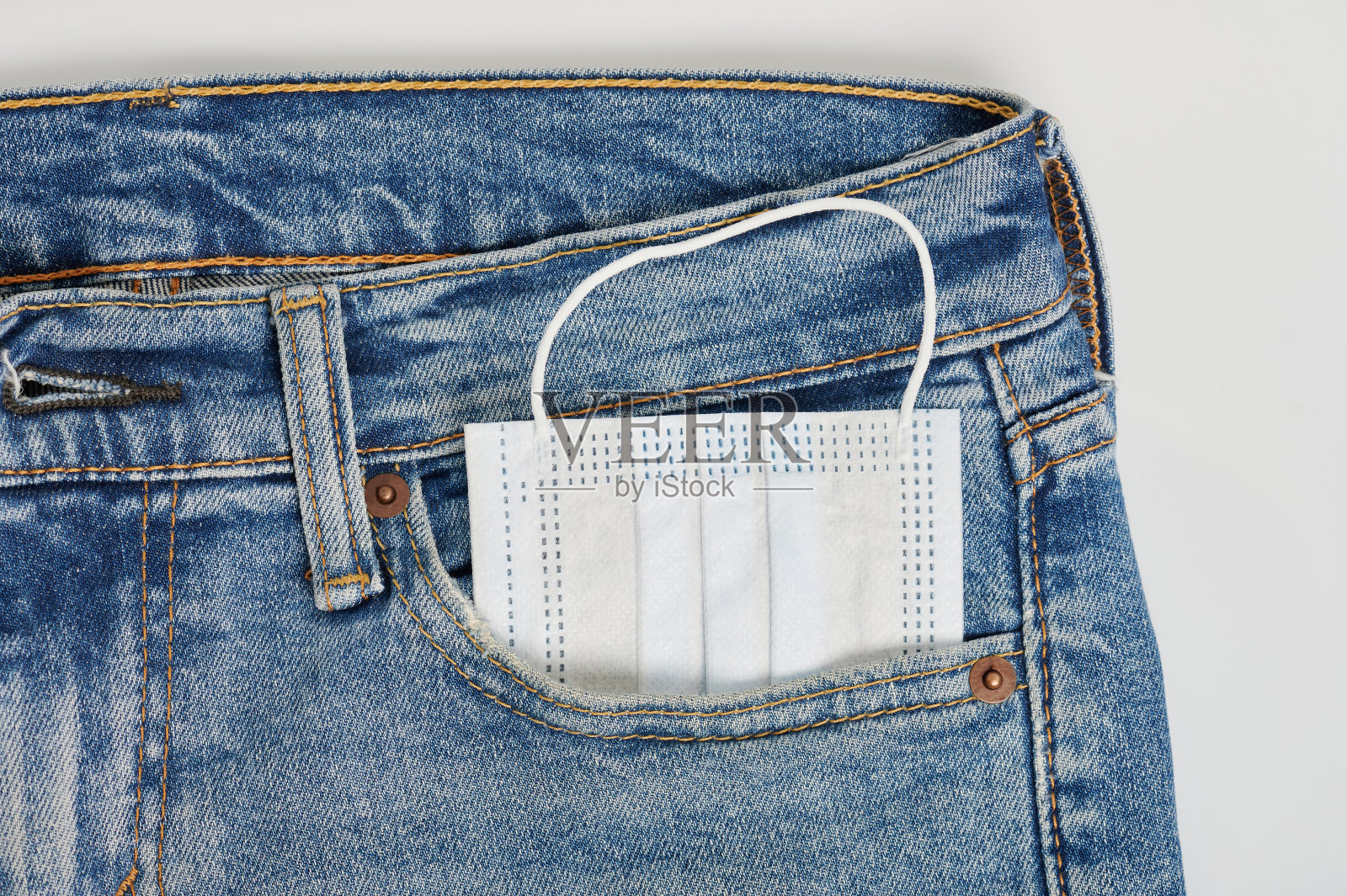 面罩在牛仔裤裤子口袋里照片摄影图片