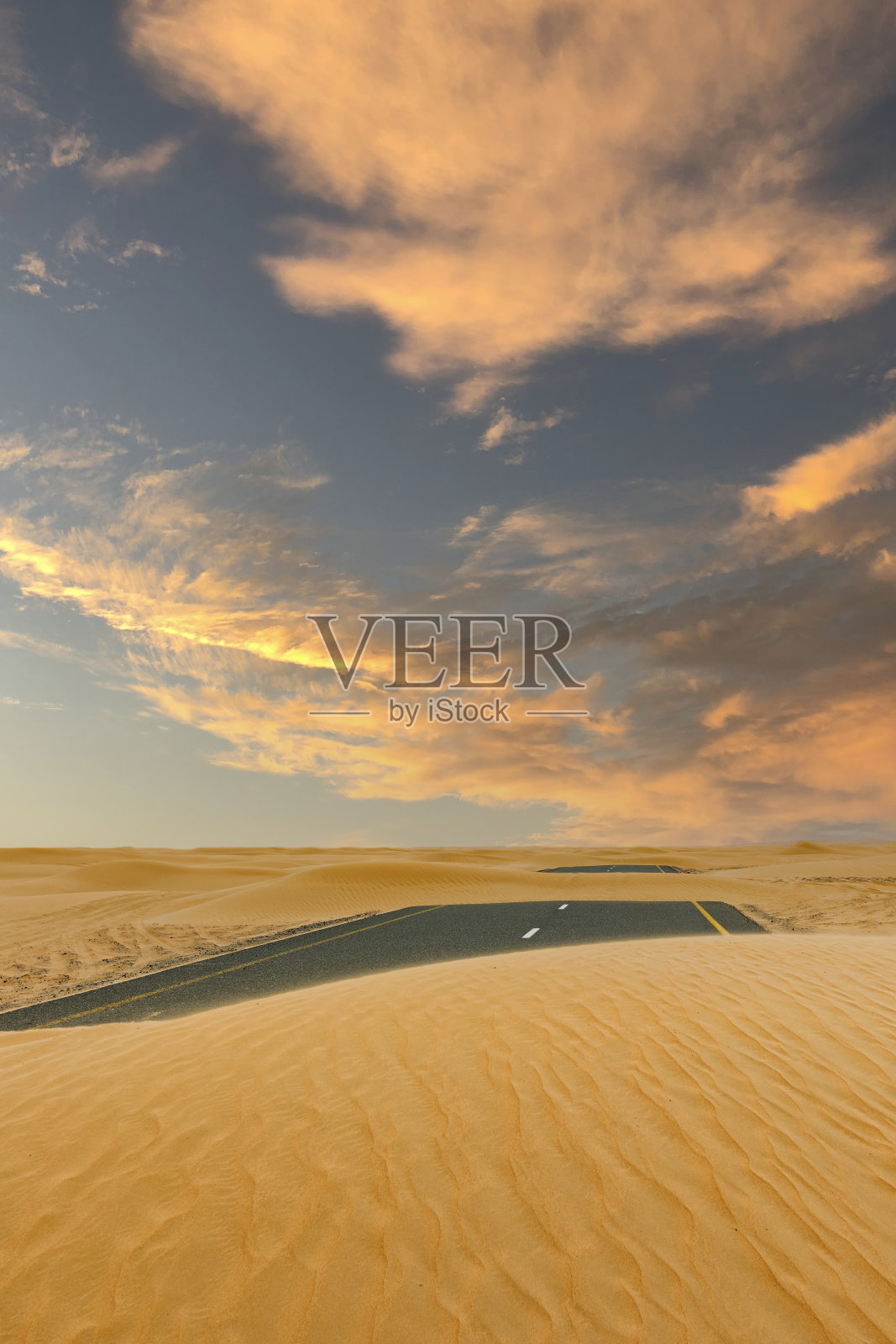 (选择性聚焦)令人惊叹的景象，一条被沙丘覆盖的废弃道路穿过迪拜沙漠。迪拜，阿拉伯联合酋长国。照片摄影图片