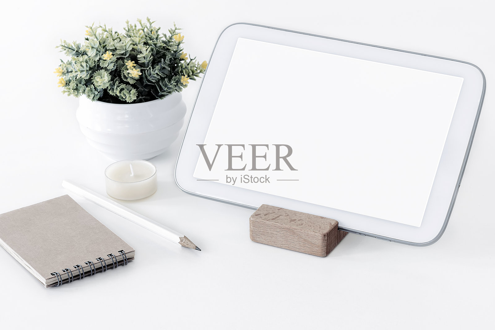 原型空白屏幕白色平板电脑小笔记本和室内植物在白色桌面，白色背景，复制空间。照片摄影图片