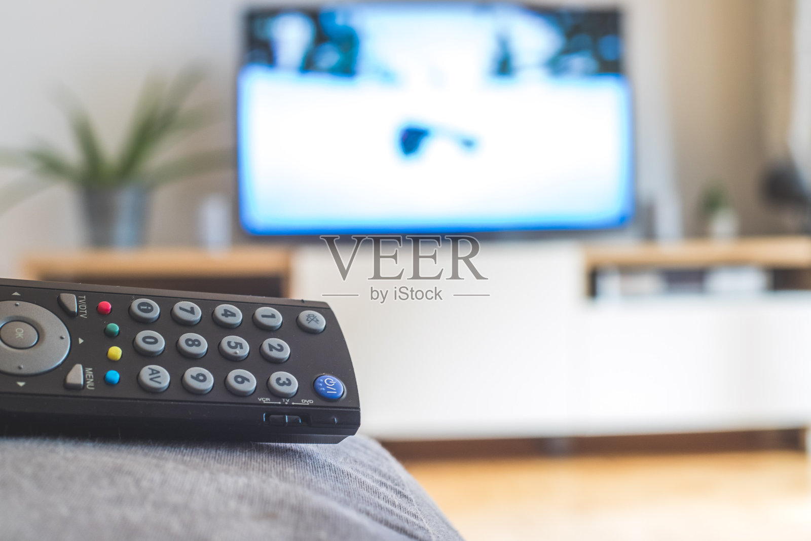 沙发上的遥控器，智能电视上的流媒体。照片摄影图片