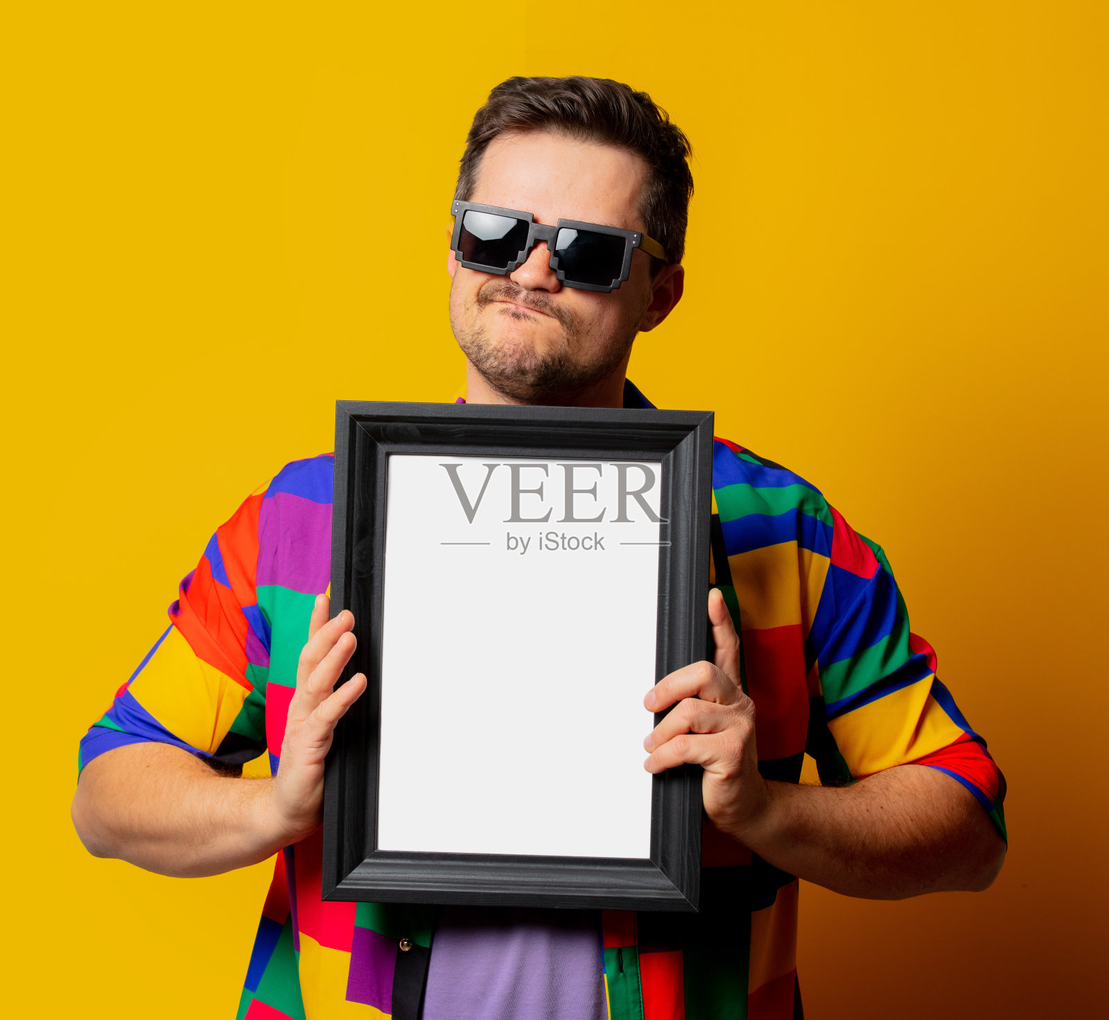 穿着90年代的衬衫，戴着太阳镜，黄色背景是相框照片摄影图片