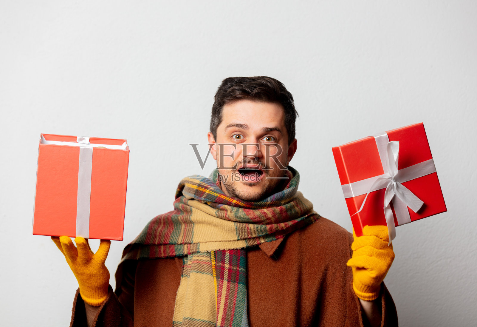 风格男子在外套和围巾与礼盒在白色背景照片摄影图片