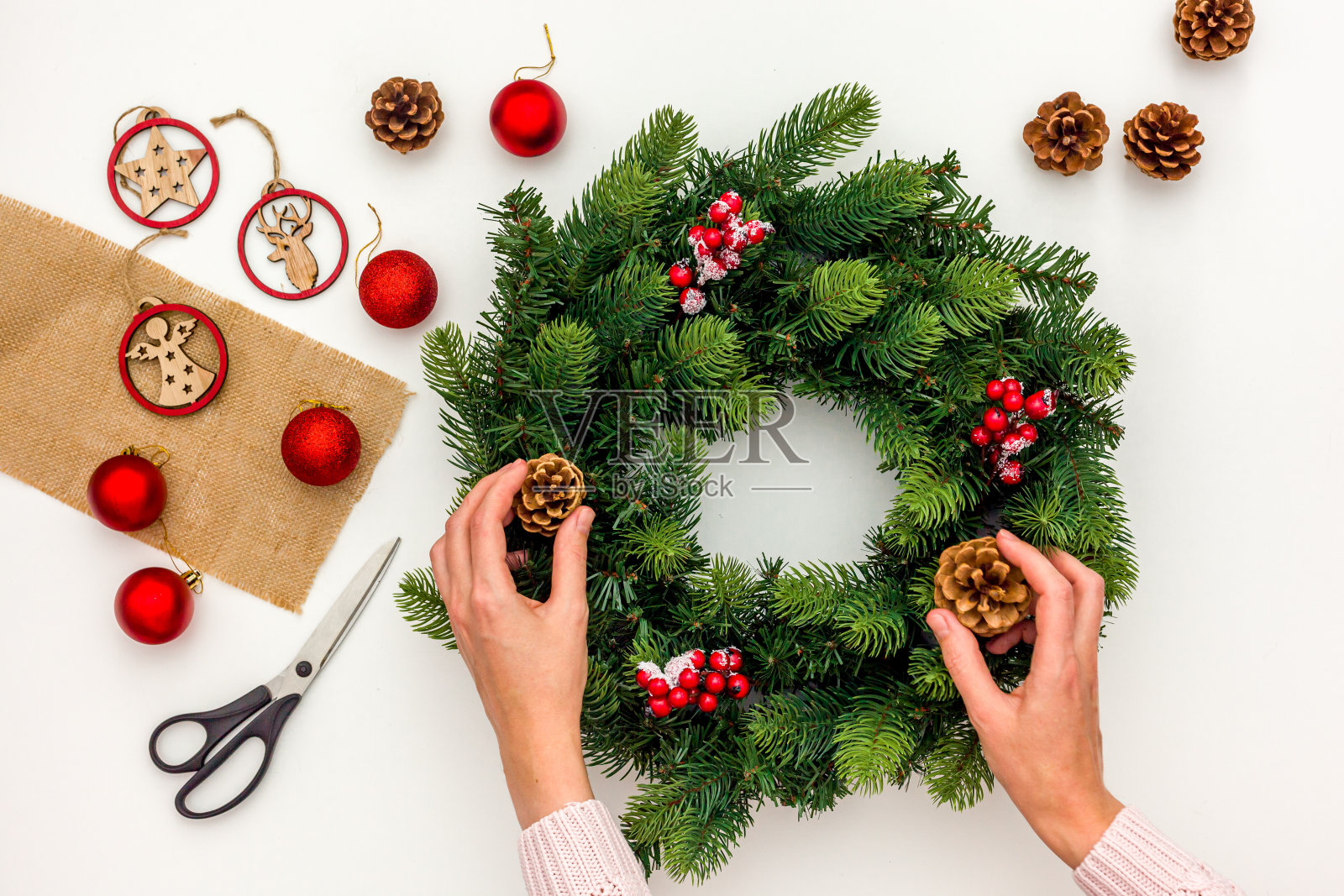 制作圣诞花环概念的过程。照片摄影图片