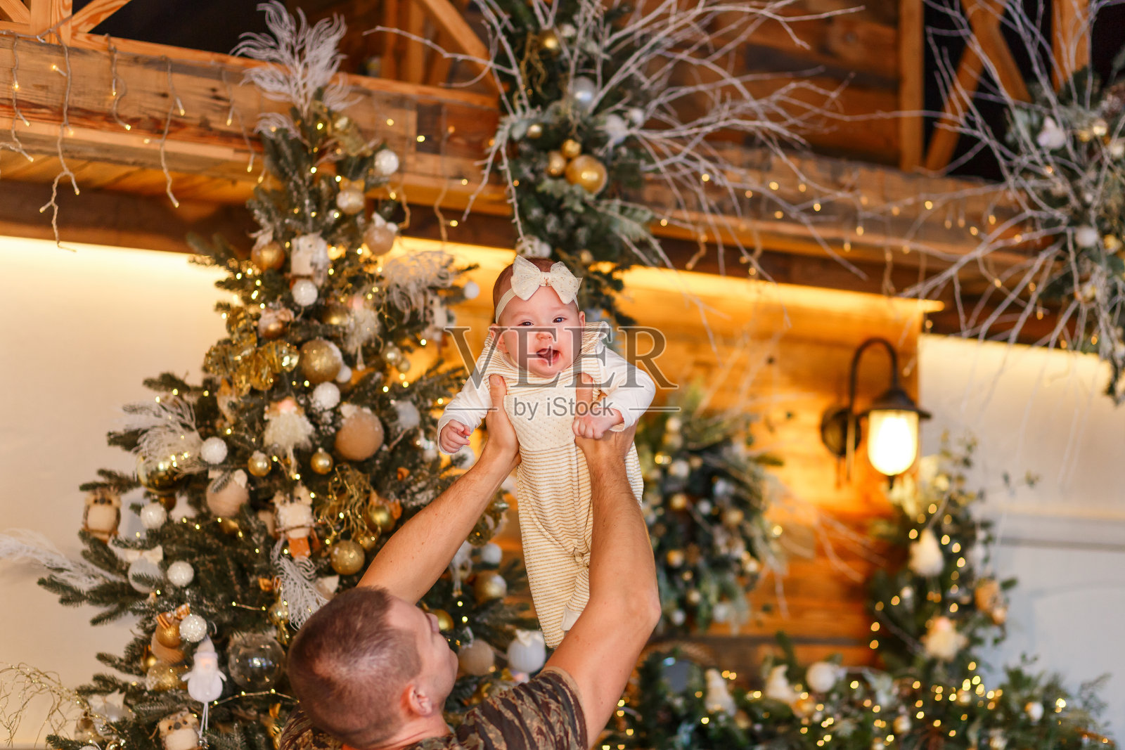 爸爸抱起六个月大的婴儿。新年前夕照片摄影图片