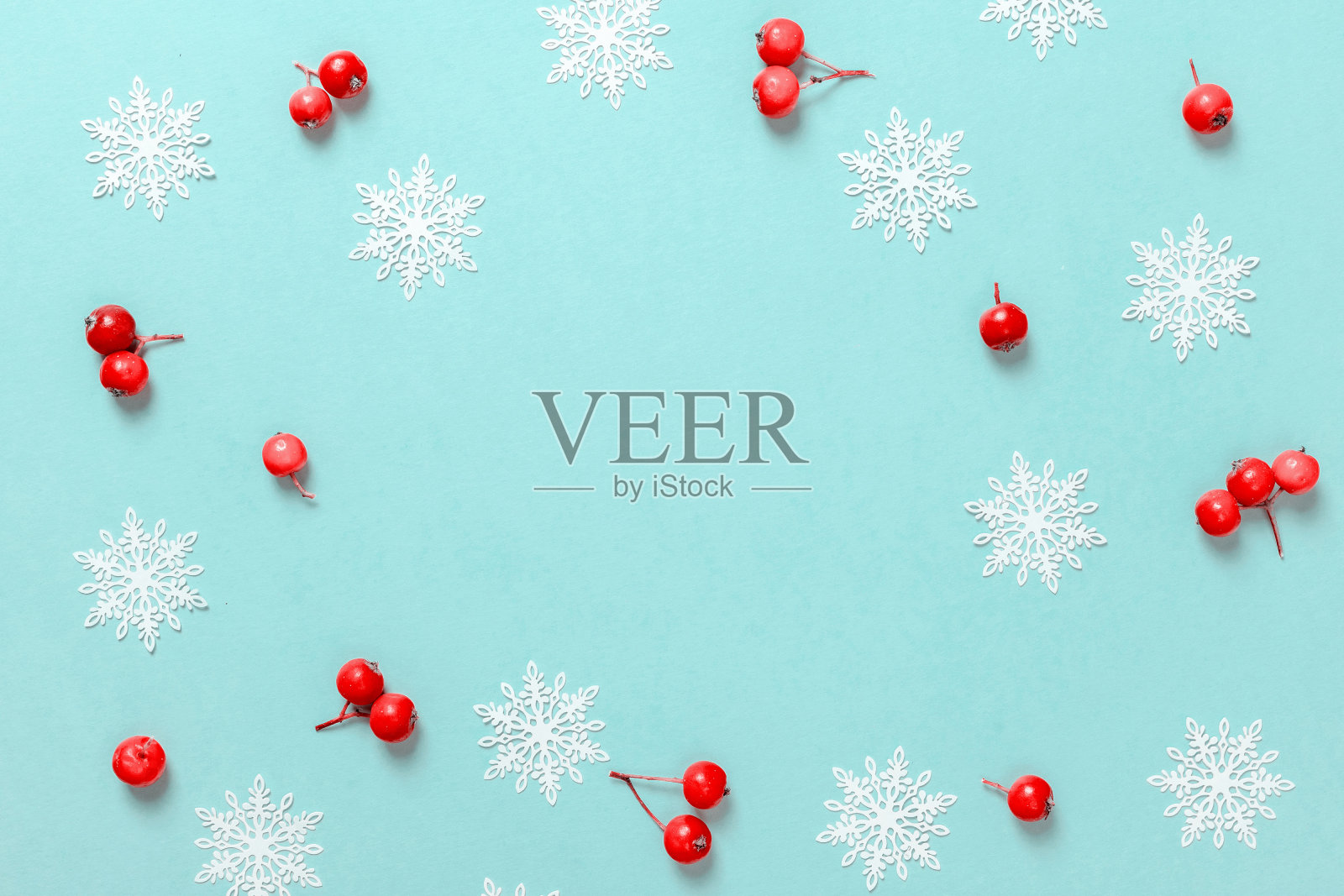 圣诞节销售。红色浆果，白色雪花的形状框架在柔和的蓝色背景贺卡。平铺，俯视图，拷贝空间。照片摄影图片