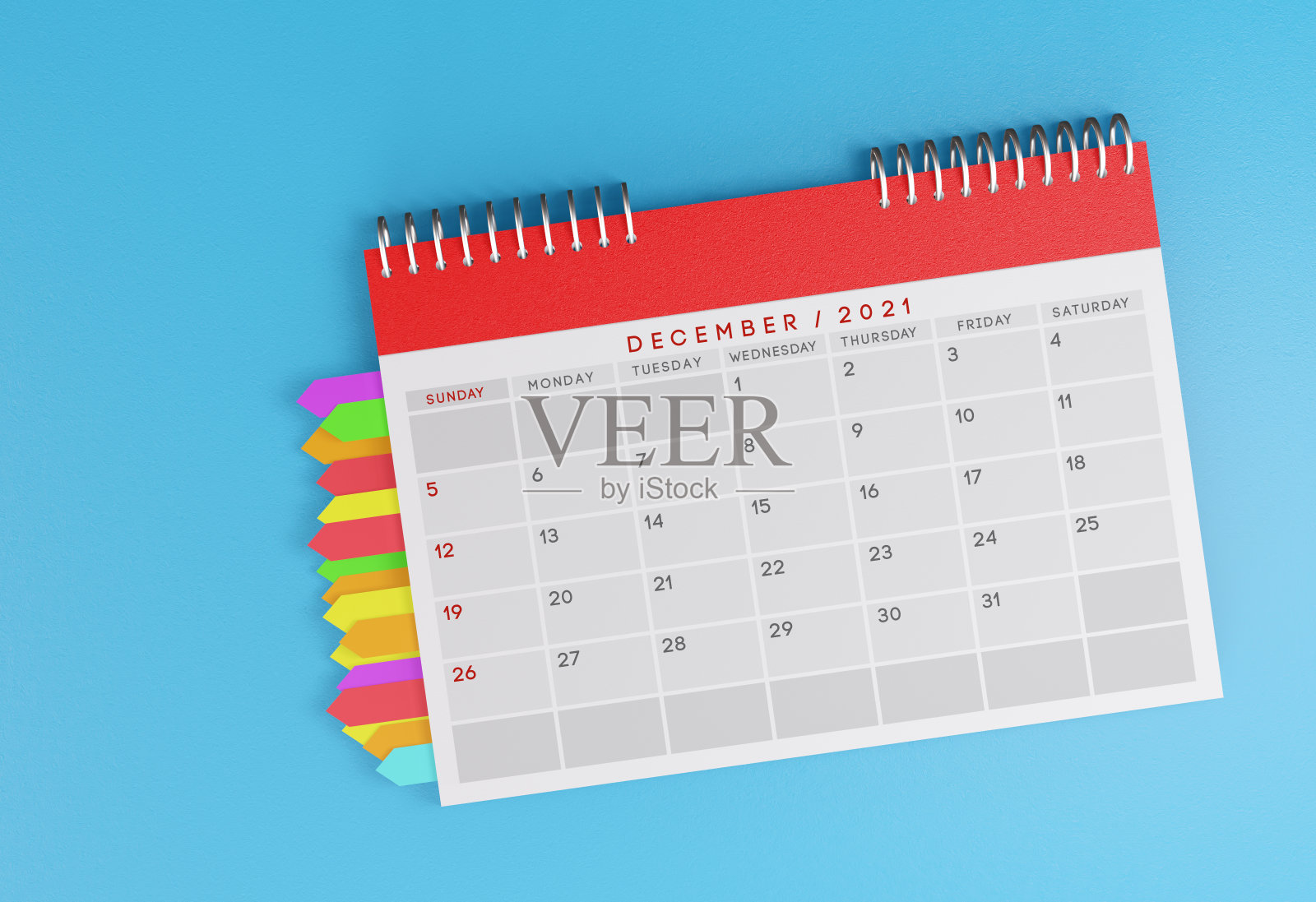 12月2021桌日历在一个蓝色的背景。页与页之间的便利贴。照片摄影图片