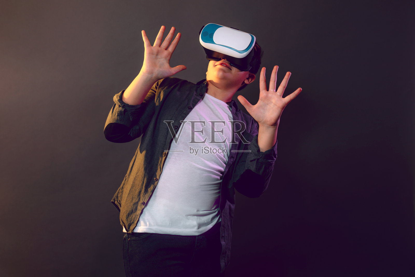 戴着虚拟现实眼镜的孩子很惊讶照片摄影图片