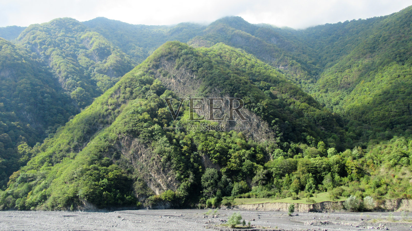 美丽的景色，一个巨大的绿色高加索山区森林和蓝色明亮的天空与白云照片摄影图片