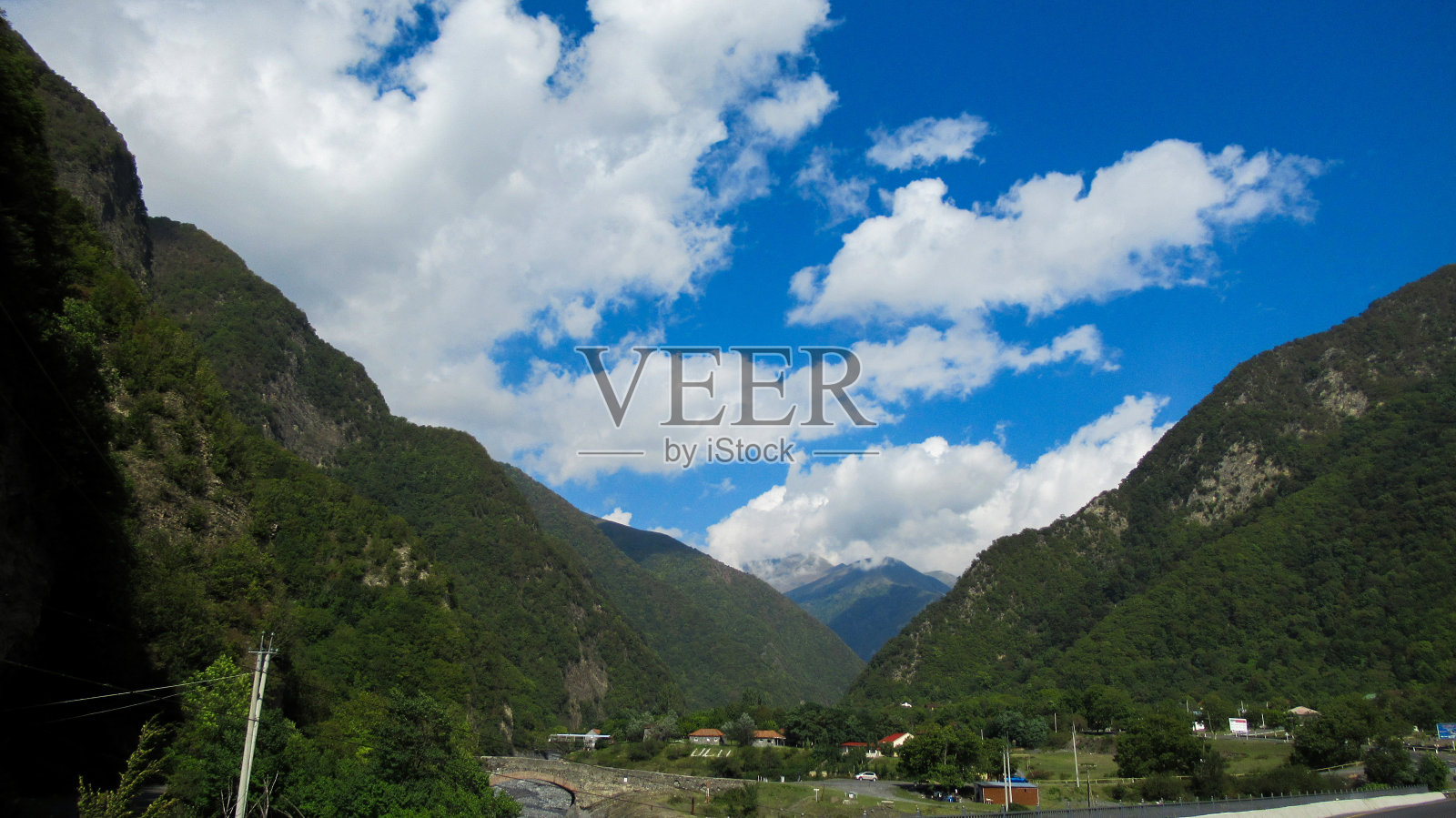 美丽的景色，一个巨大的绿色高加索山区森林和蓝色明亮的天空与白云照片摄影图片