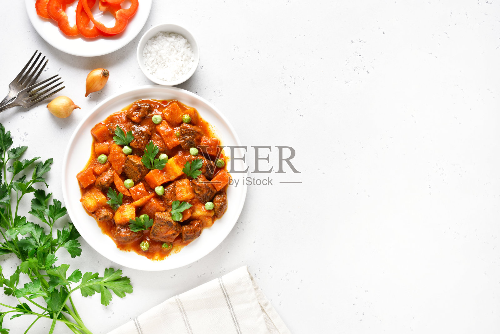 蕃茄汁炖牛肉，土豆和胡萝卜放在白盘子里照片摄影图片