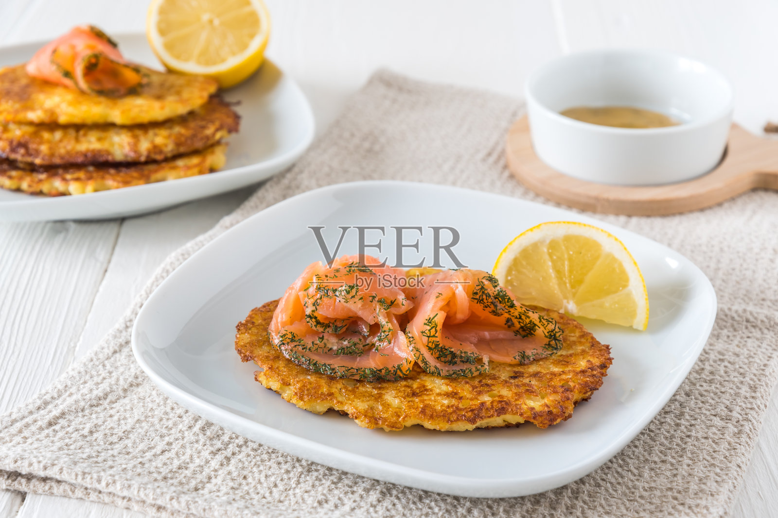 土豆煎饼配鲑鱼，柠檬和芥末酱在白色的背景照片摄影图片