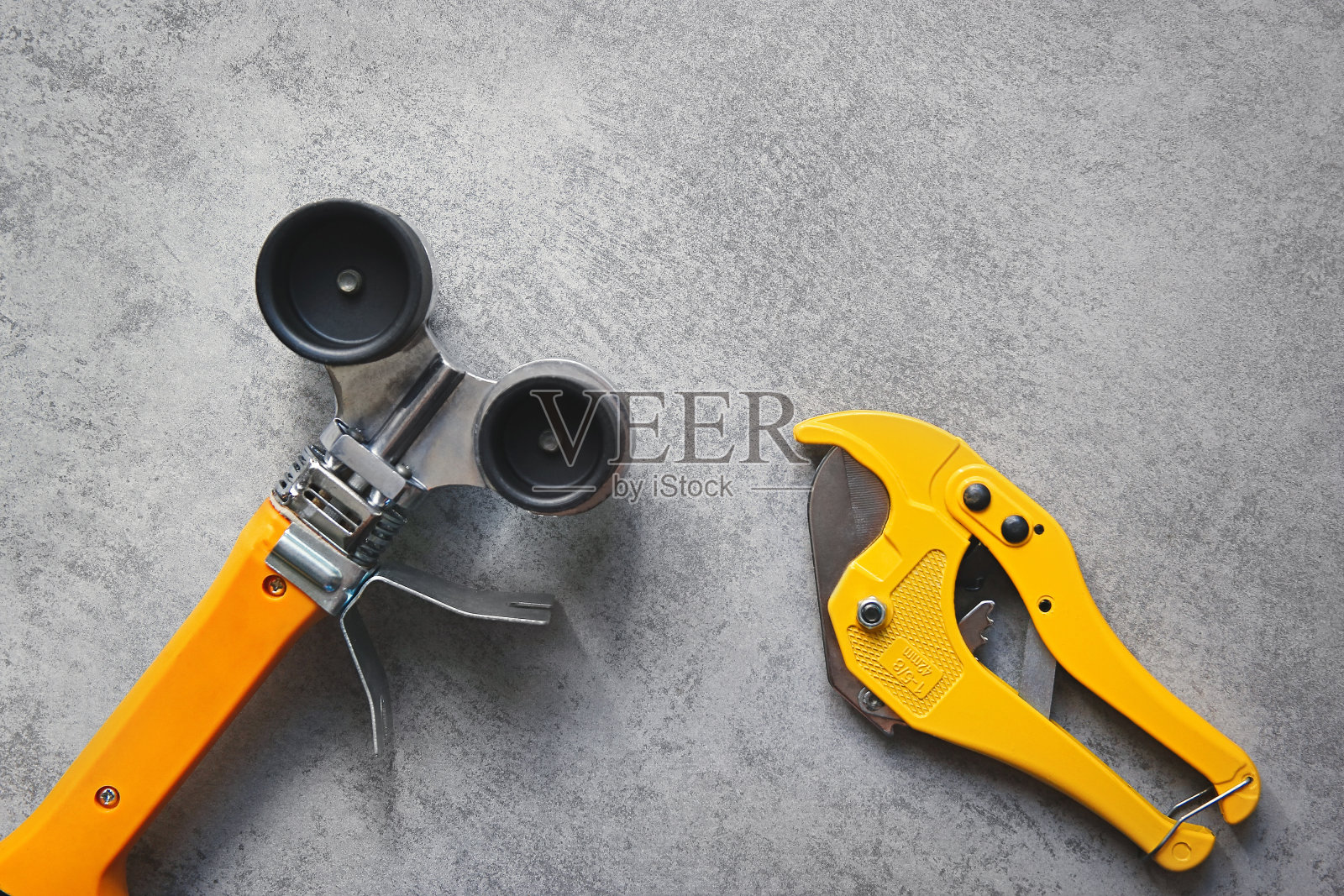 PVC管用黄色烙铁和管剪，供水管道工具在灰色背景上照片摄影图片