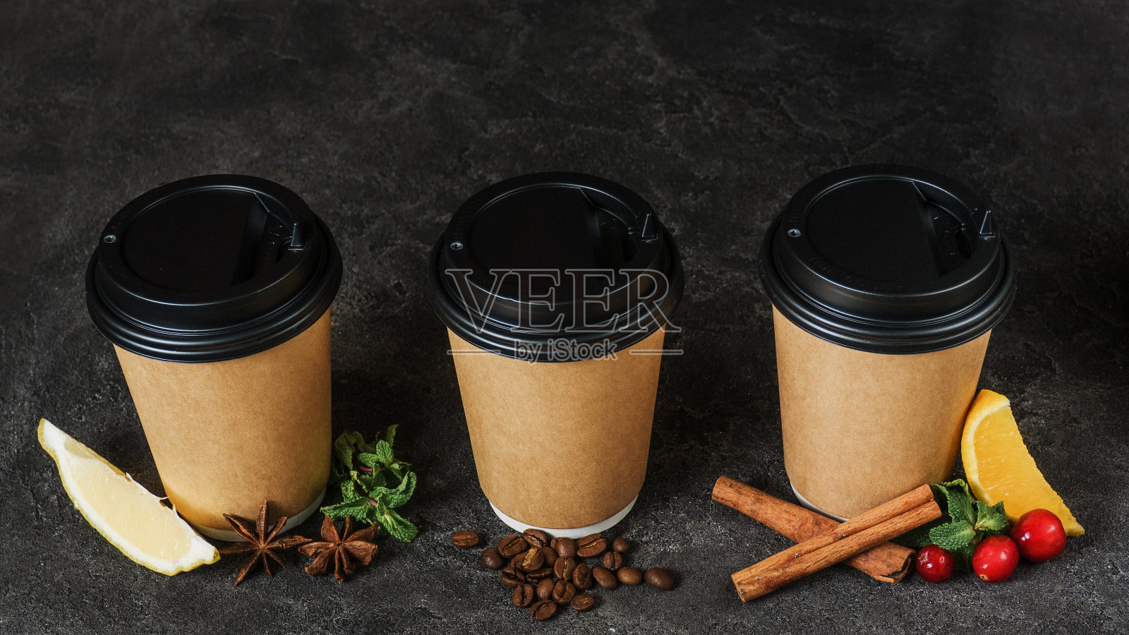 圣诞饮料在一次性杯子。茶加柠檬和八角茴香，新煮的咖啡和茶加蔓越莓和肉桂。冬天喝热饮。新年的菜单。季节性冬季饮料。照片摄影图片