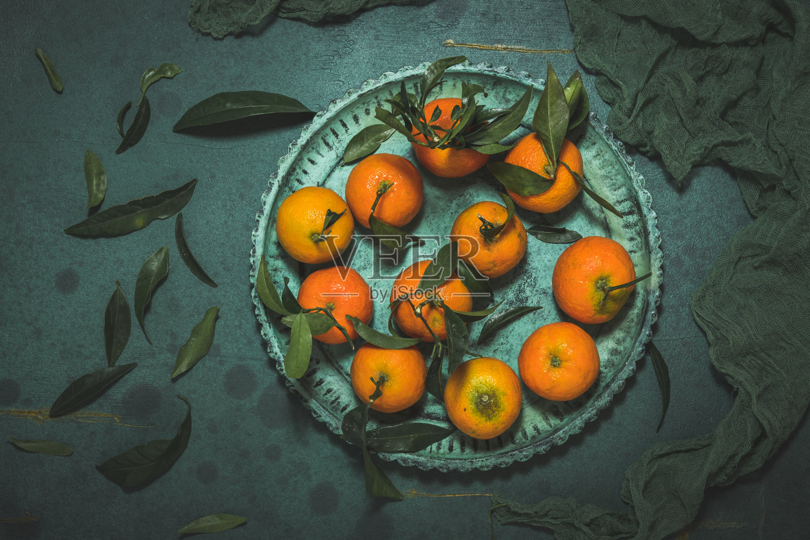 橙色与叶子在绿色的盘子在绿色的背景，俯视图照片摄影图片