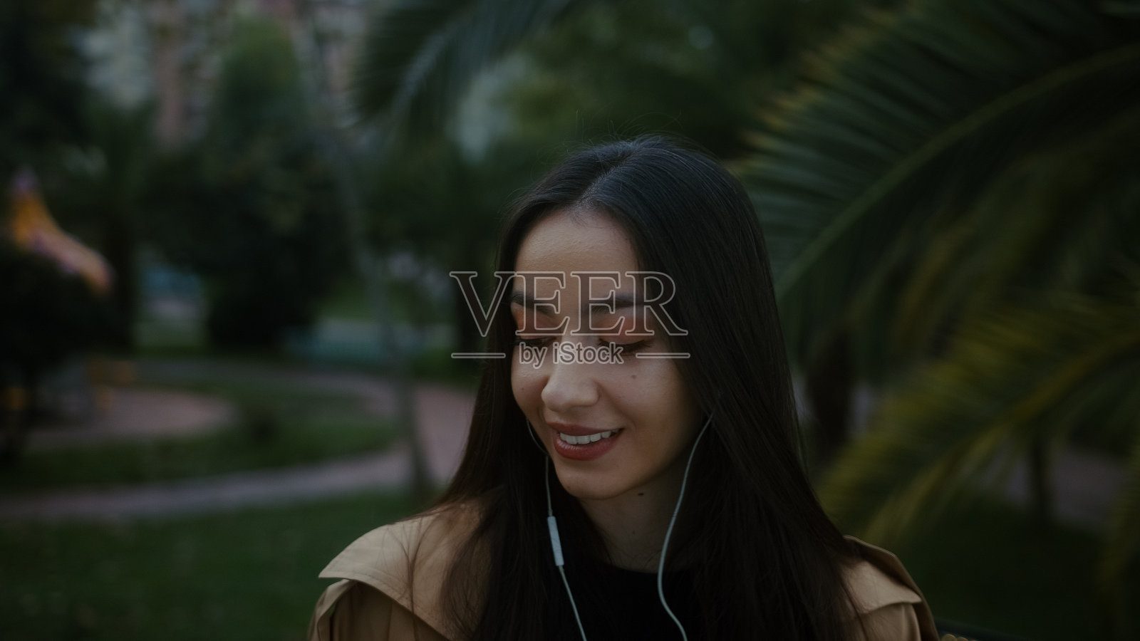 漂亮的年轻微笑的女人与她的电话和耳机听音乐和快乐的舞蹈步行，音乐舞蹈和生活理念照片摄影图片