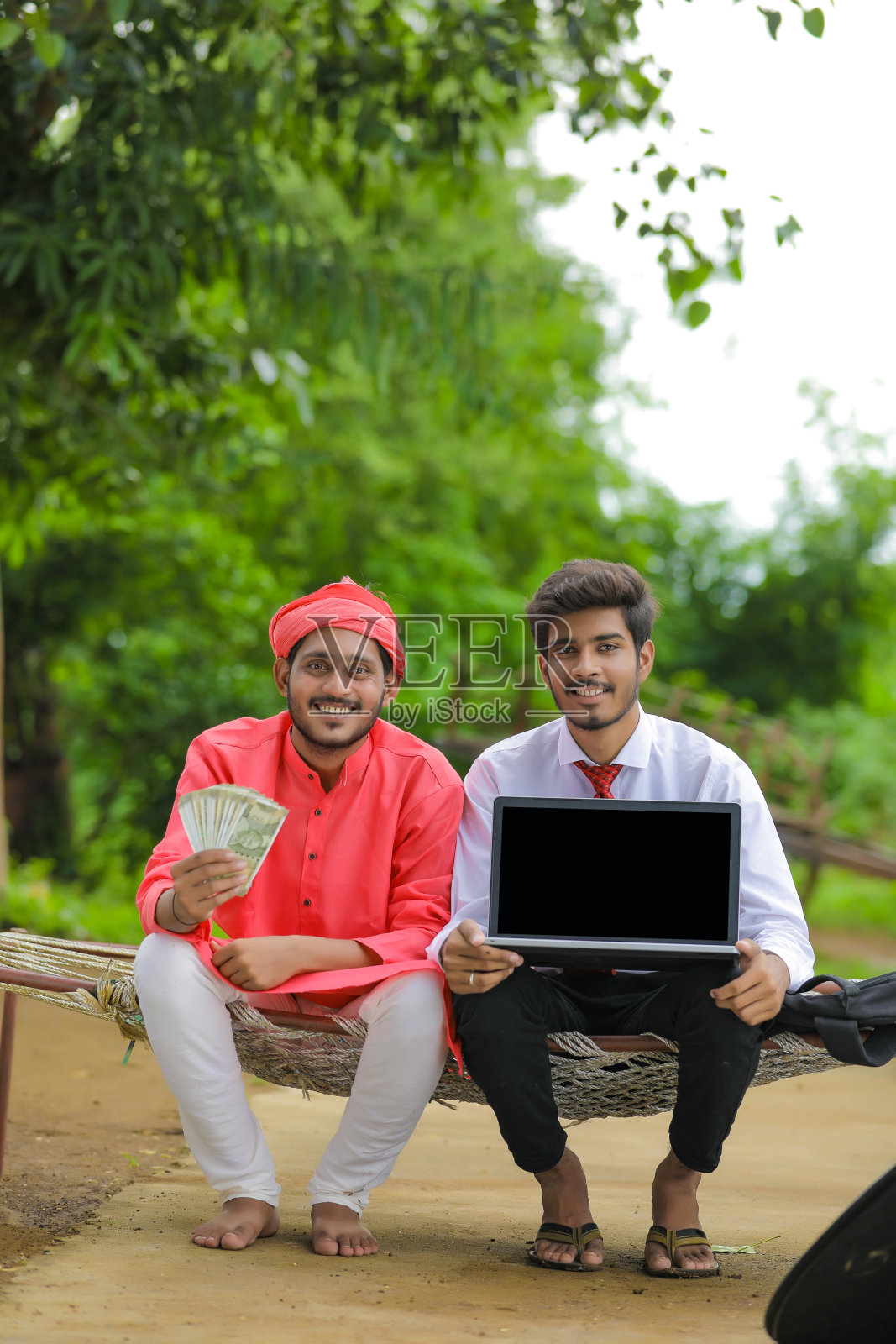 年轻的印度农民与银行职员在家展示印度卢比照片摄影图片