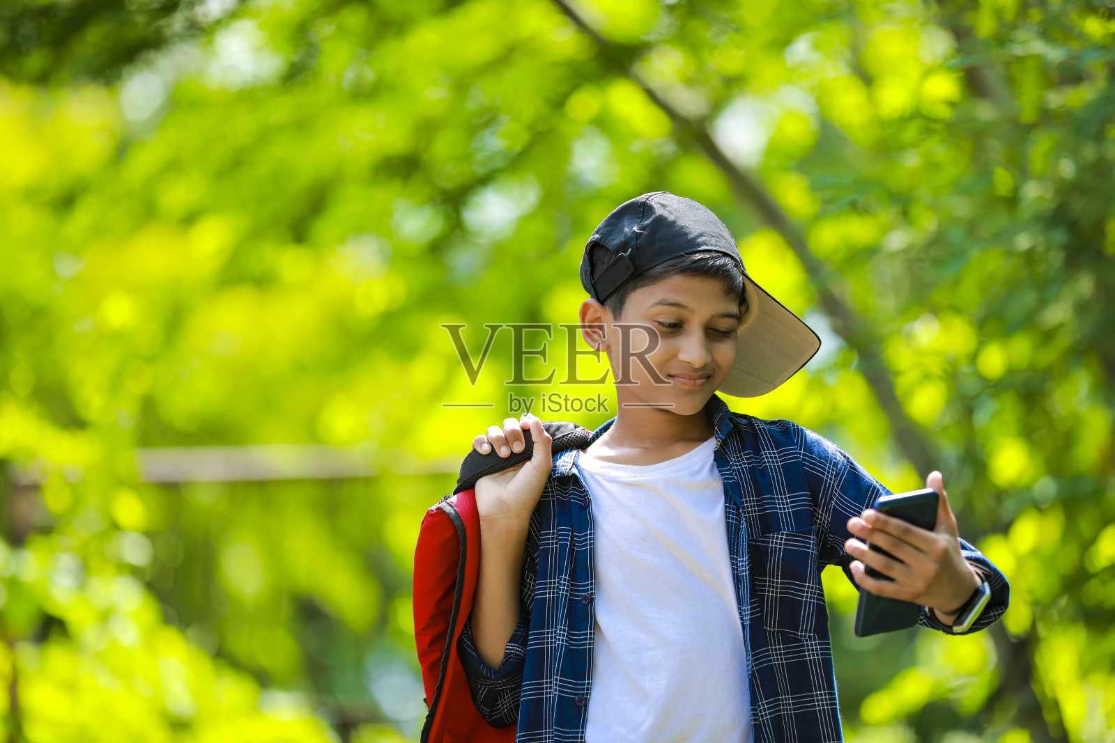 人、孩子、技术和交流概念——可爱的印度孩子在用智能手机聊天照片摄影图片