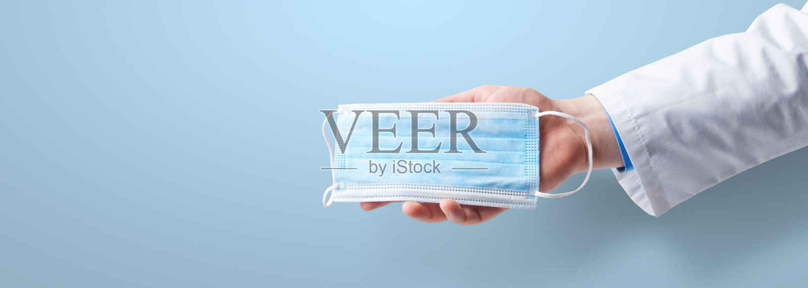 手持医用手套，手持医用防护口罩。照片摄影图片