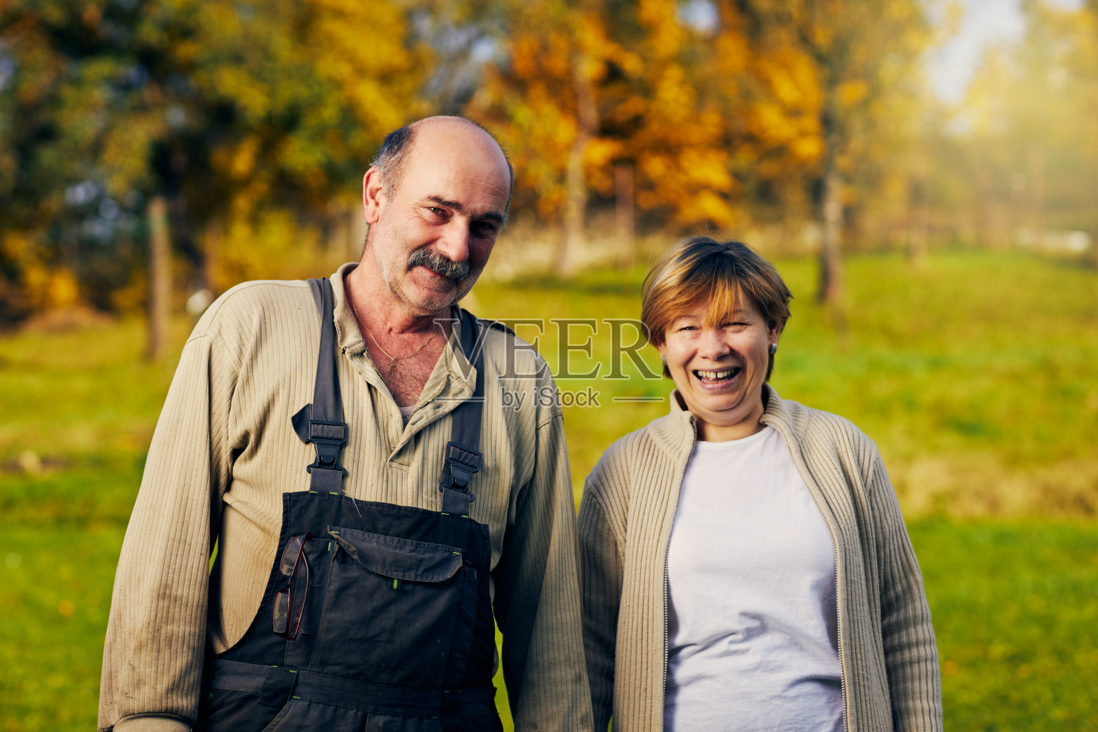 这是一对快乐的老年夫妇在秋季花园中的肖像照片摄影图片