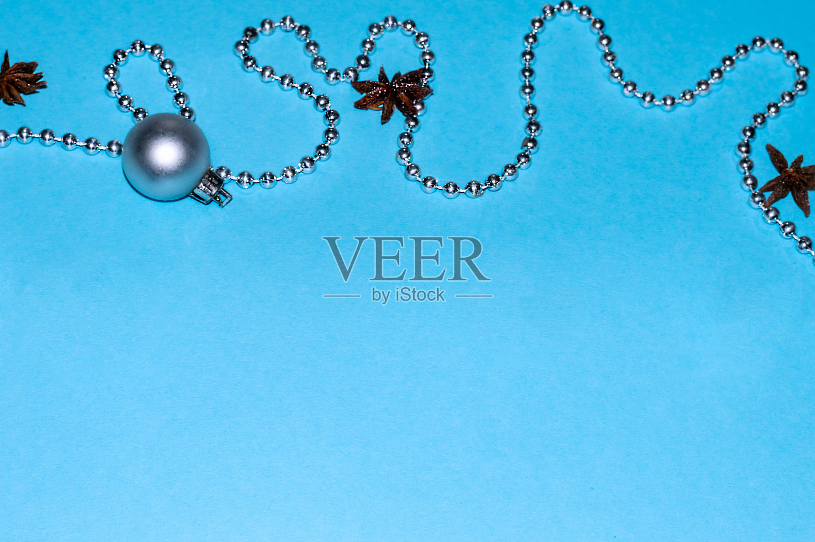 圣诞组成。贺卡。圣诞树上蓬松的树枝，上面有圣诞球和蓝色背景上的珠子花环。水平方向。大计划。俯视图，复制空间。家庭度假。圣诞节。照片摄影图片