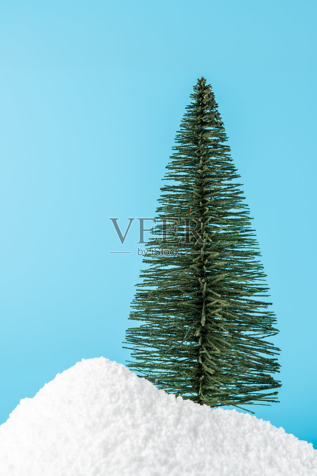 圣诞树在雪在蓝色的背景。最小的新年概念。照片摄影图片