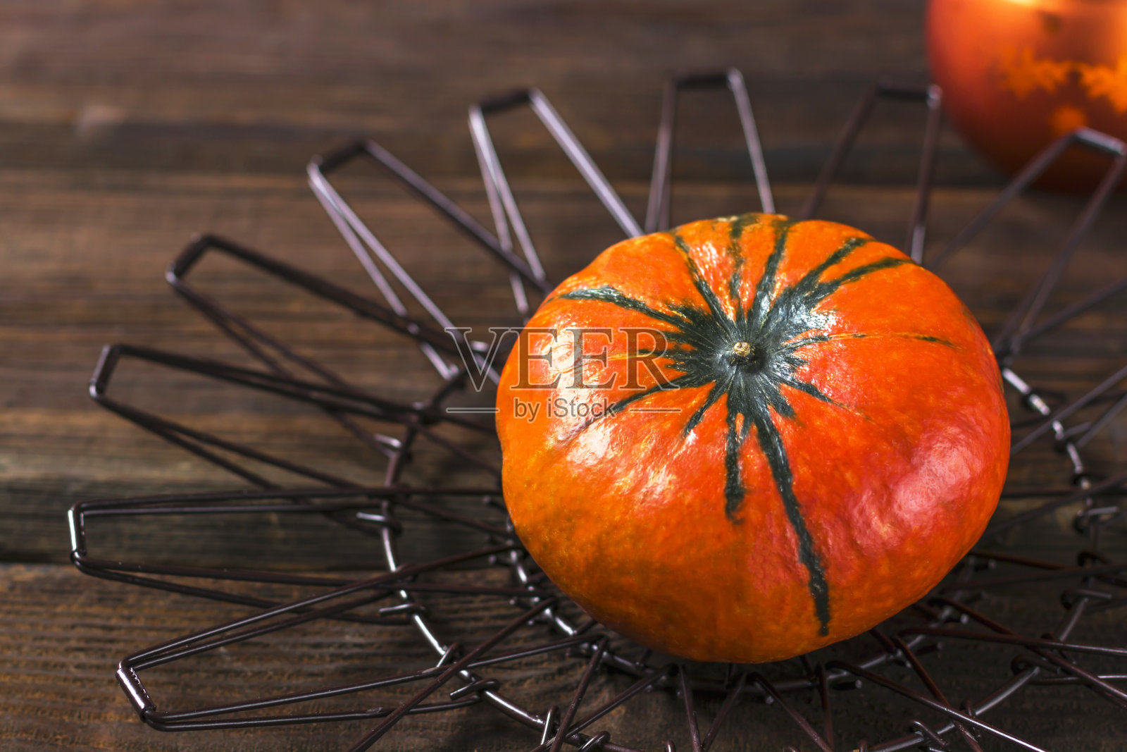 秋天的成分。木质背景上镂空金属支架上的南瓜。秋天、万圣节、感恩节概念。平躺，俯视图。照片摄影图片