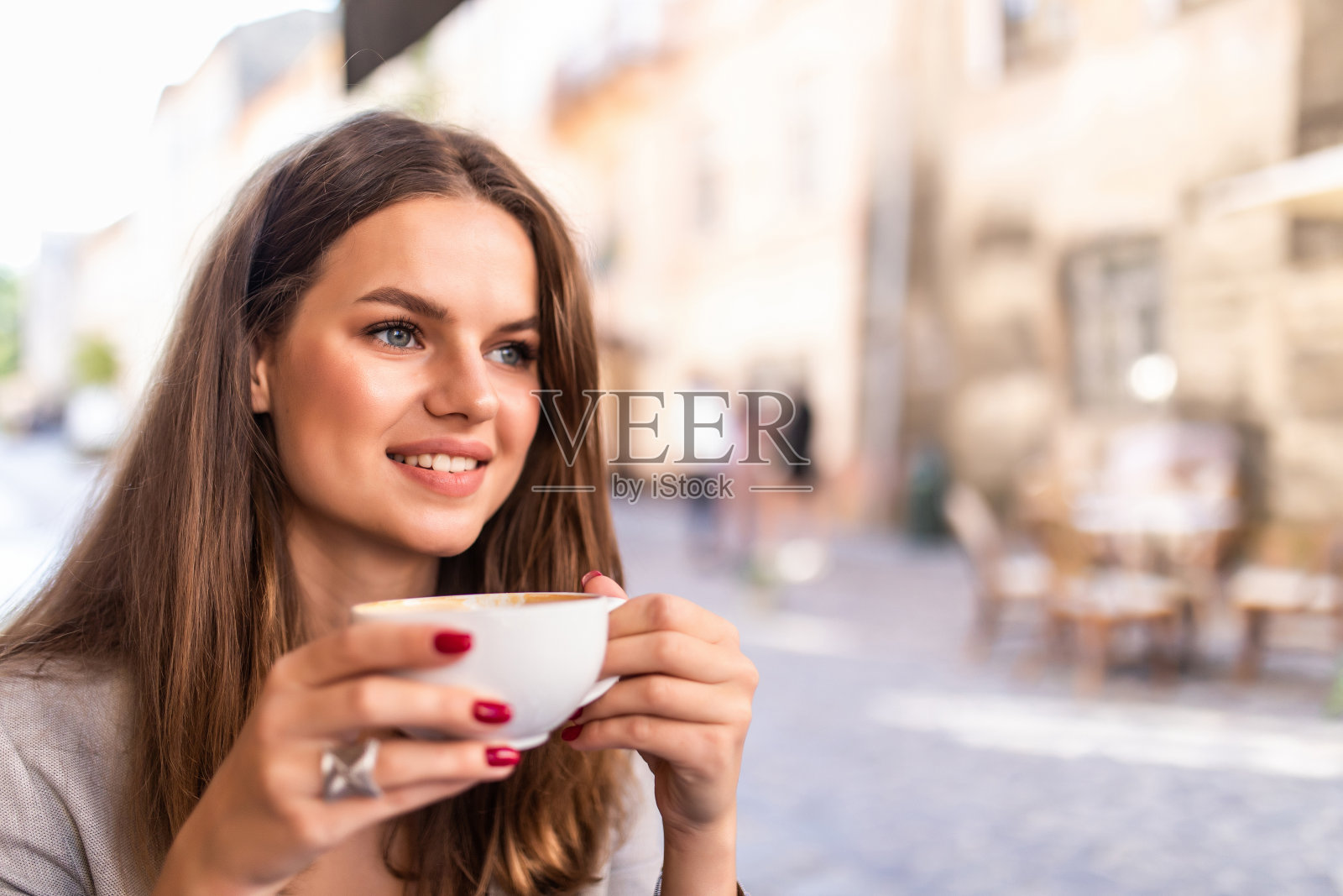 一个年轻女人享受咖啡的肖像坐在户外的咖啡馆在上午照片摄影图片