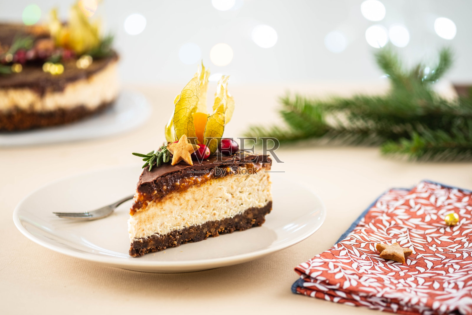 圣诞背景上有坚果的圣诞奶酪蛋糕。照片摄影图片