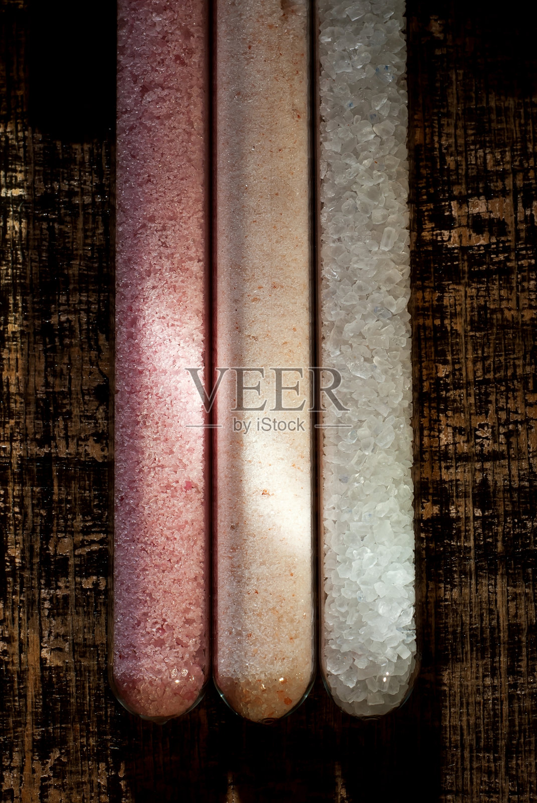 伊朗，喜马拉雅和西藏盐在一个玻璃罐关闭。盐在一块又黑又旧的破木板上。作为一种艺术效果来对比戏剧性的光线。免费空间和复制空间的文本附近的调味品。照片摄影图片