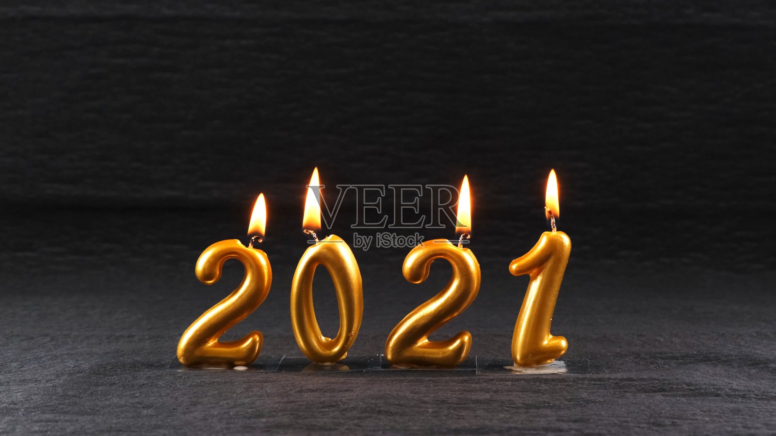 黑色背景上燃烧着2021年的金色新年蜡烛。现代概念照片摄影图片