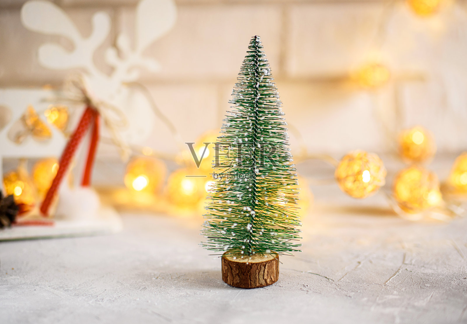 新年贺卡在明亮的背景上。小eve树，圣诞树球，彩灯。圣诞快乐照片摄影图片