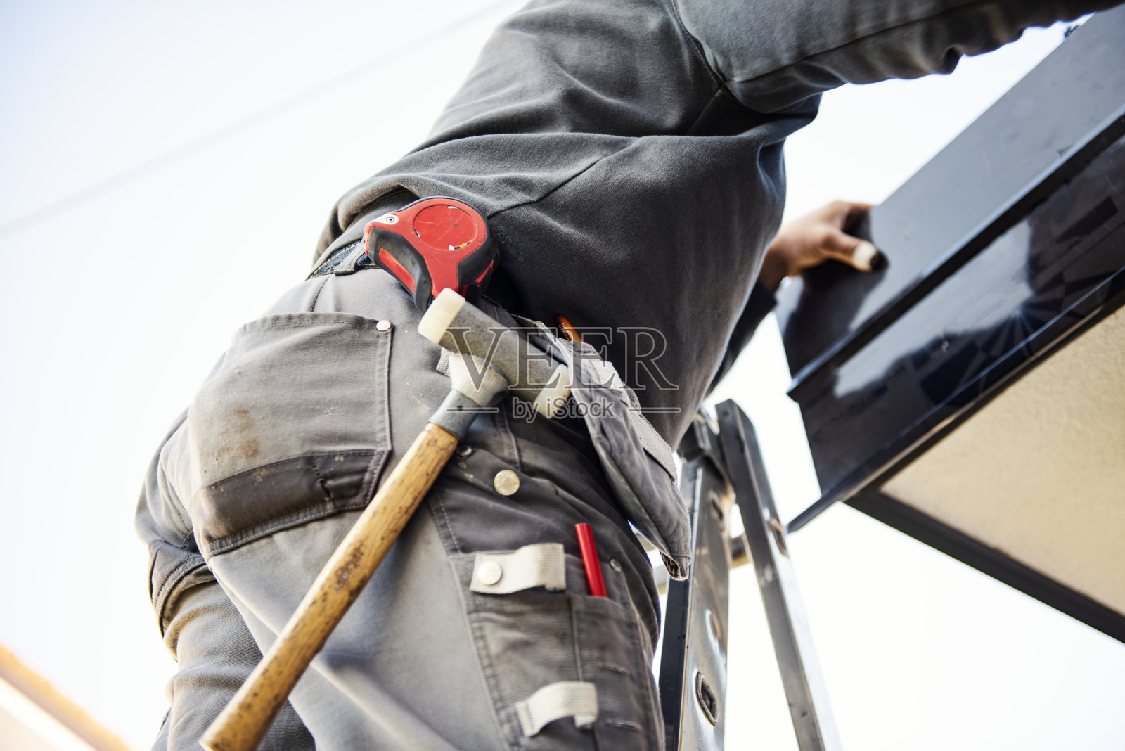 在屋顶安装金属瓦的工人照片摄影图片