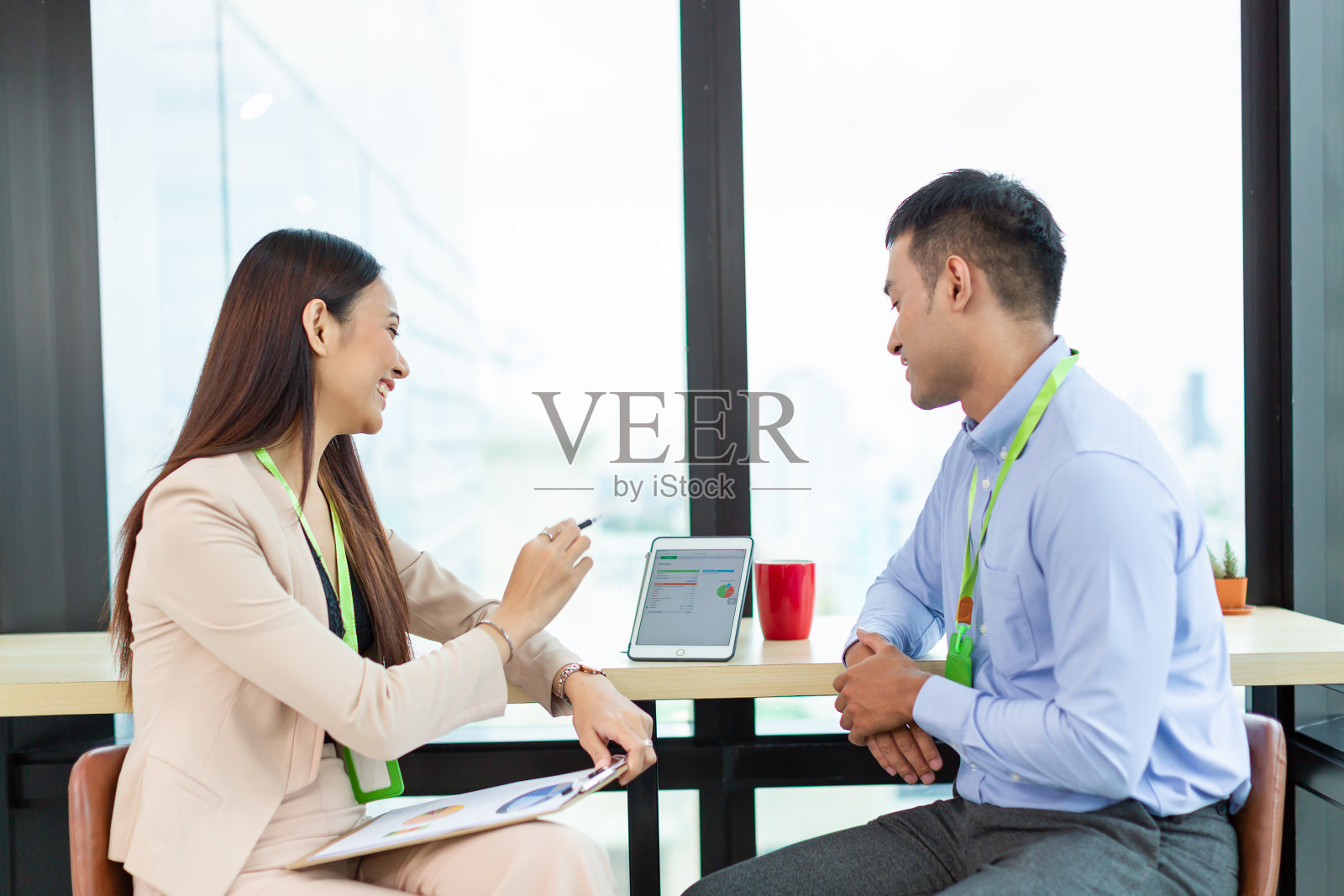 亚洲商人和女商人解释工作用纸图表和数字平板电脑。一群亚洲商人在现代化的办公室里谈论新项目的想法。商务人士和办公室概念照片摄影图片