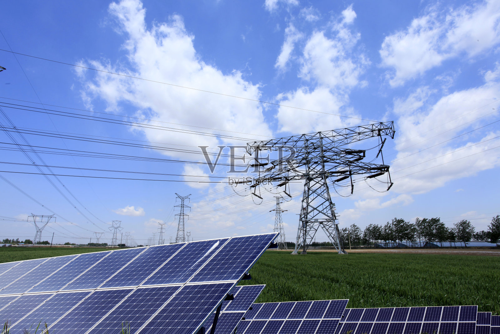 高压塔和太阳能电池板。照片摄影图片