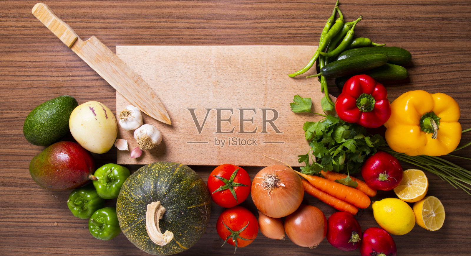 天然健康蔬菜辣椒、黄瓜、洋葱、萝卜、番茄、胡萝卜、西葫芦、大蒜、柠檬、切菜板照片摄影图片