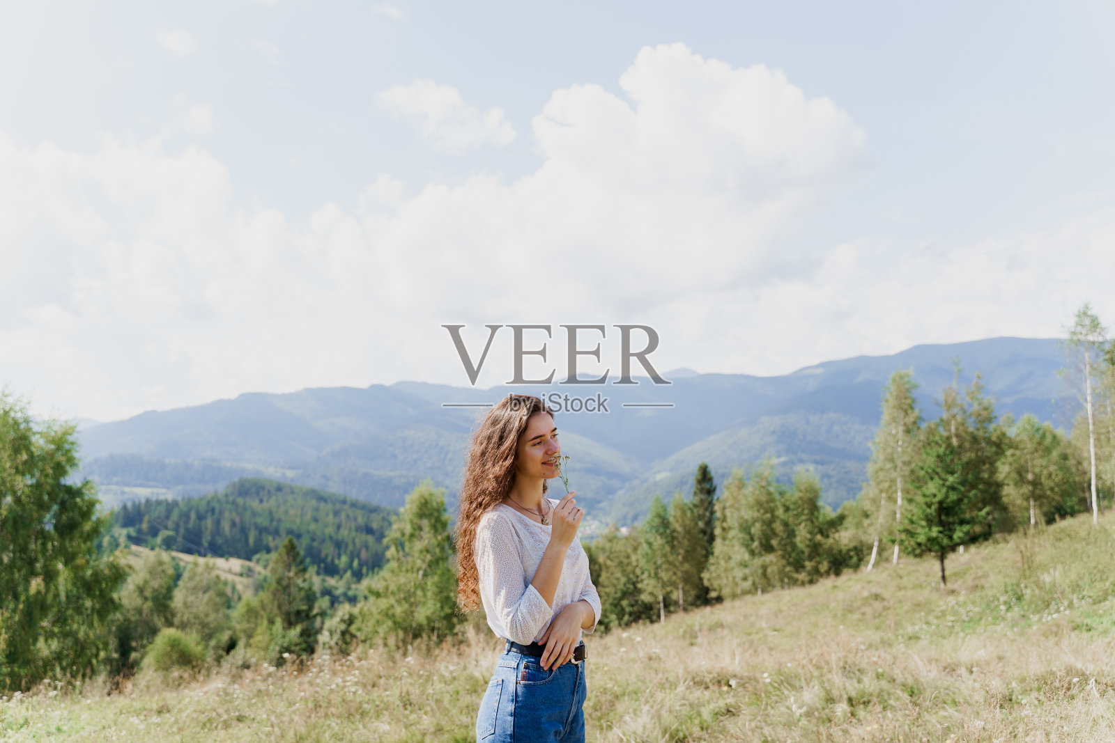 女孩欣赏着山景。在喀尔巴阡山脉感受自由。在乌克兰旅游。照片摄影图片