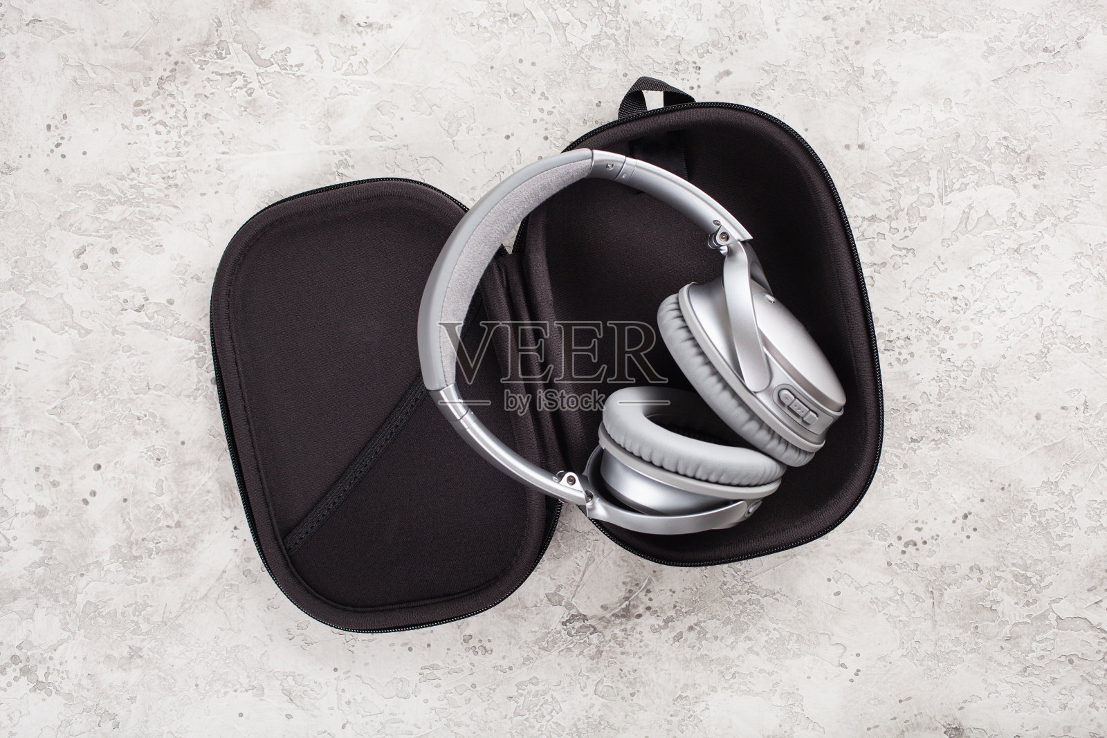 混凝土背景下的现代银色无线耳机照片摄影图片