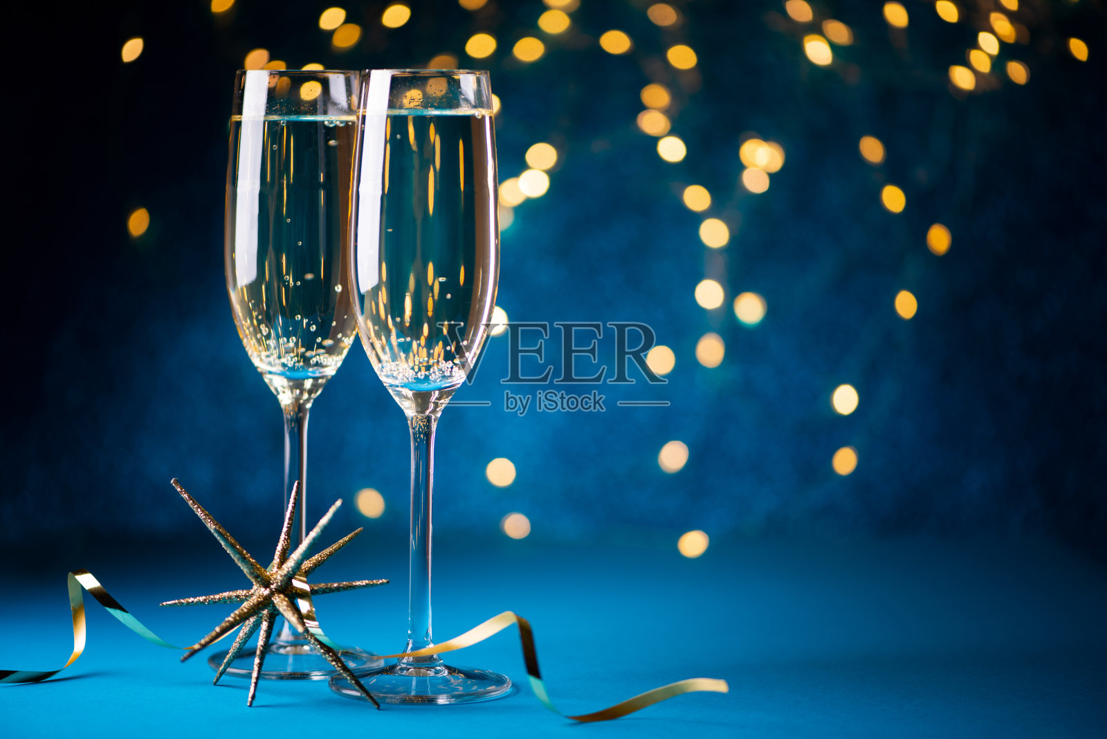 以散景灯光为背景，两杯香槟。新年庆祝概念照片摄影图片