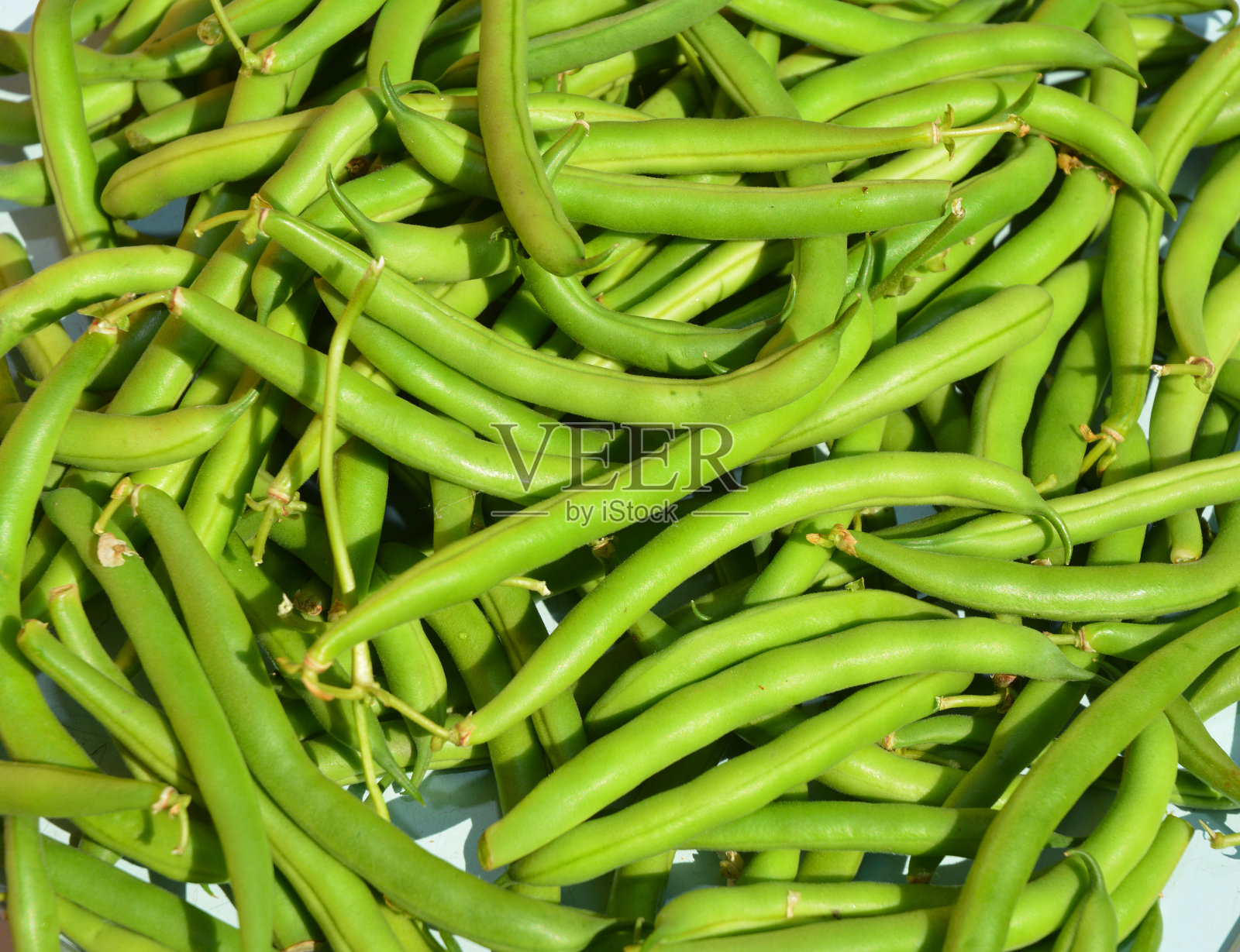 盘子里有很多生青豆。新鲜蔬菜的背景。照片摄影图片