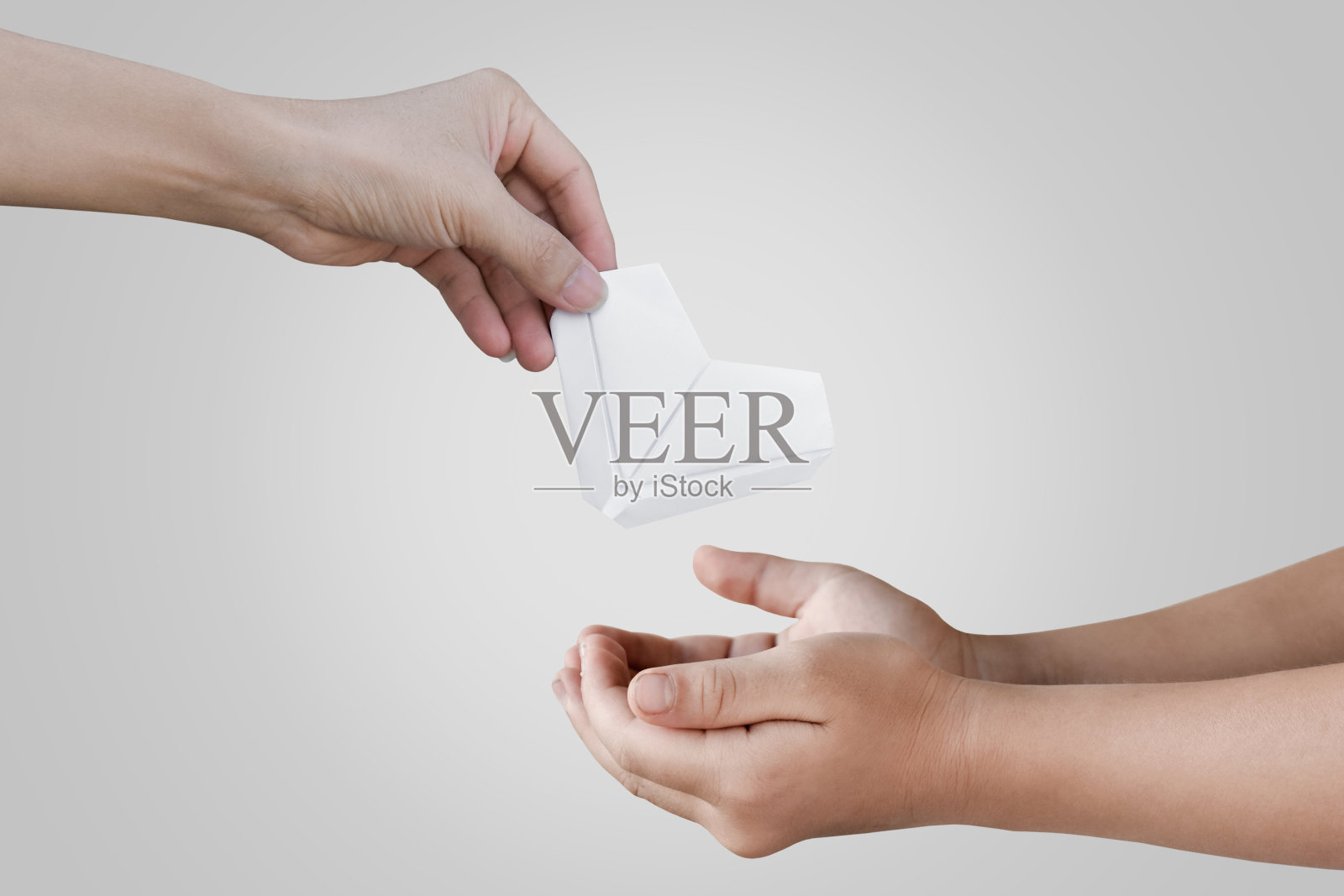 白色的折纸心在父亲和孩子女孩的手中。照片摄影图片