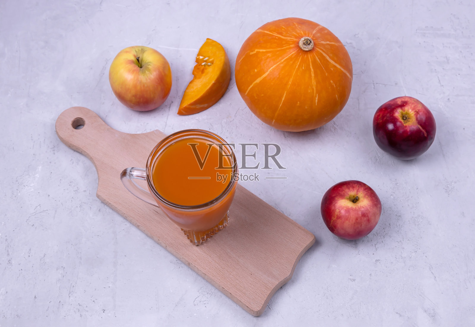 南瓜和苹果汁放在玻璃杯里，背景很亮照片摄影图片