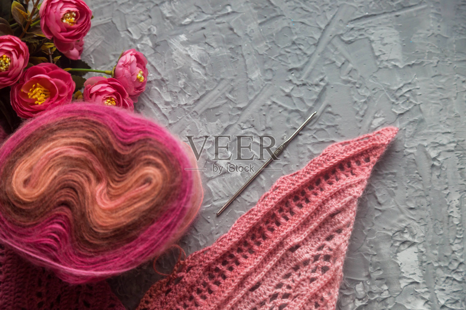 钩针flatlay背景。彩色纱线的线轴，钩针，在混凝土背景上钩针围巾，俯视图。关于刺绣和手工艺品的背景，复制空间照片摄影图片