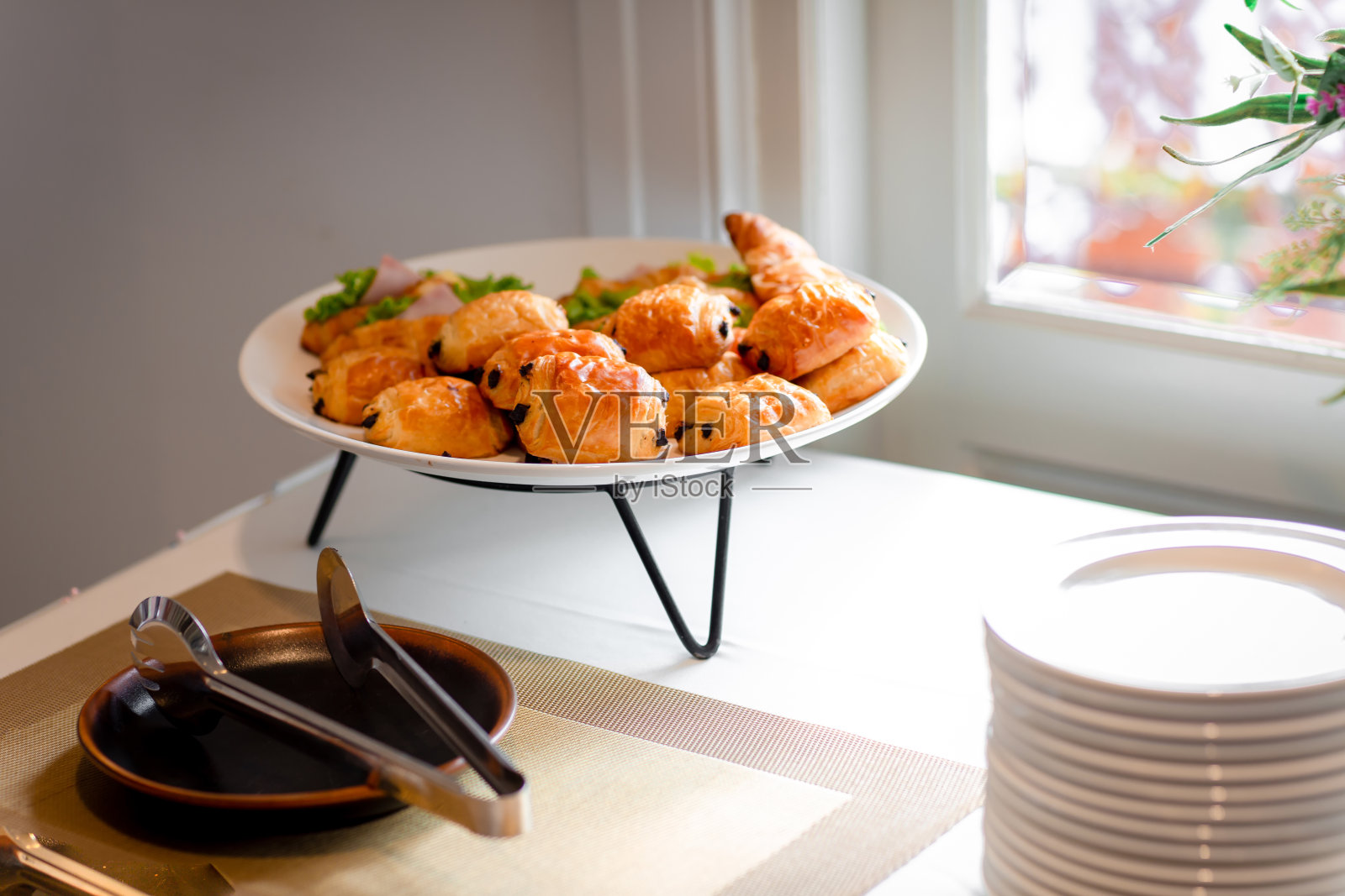 餐厅自助餐桌上的巧克力酥皮小面包。餐饮自助餐桌上有美味的食物。婚礼上的牛角面包三明治照片摄影图片