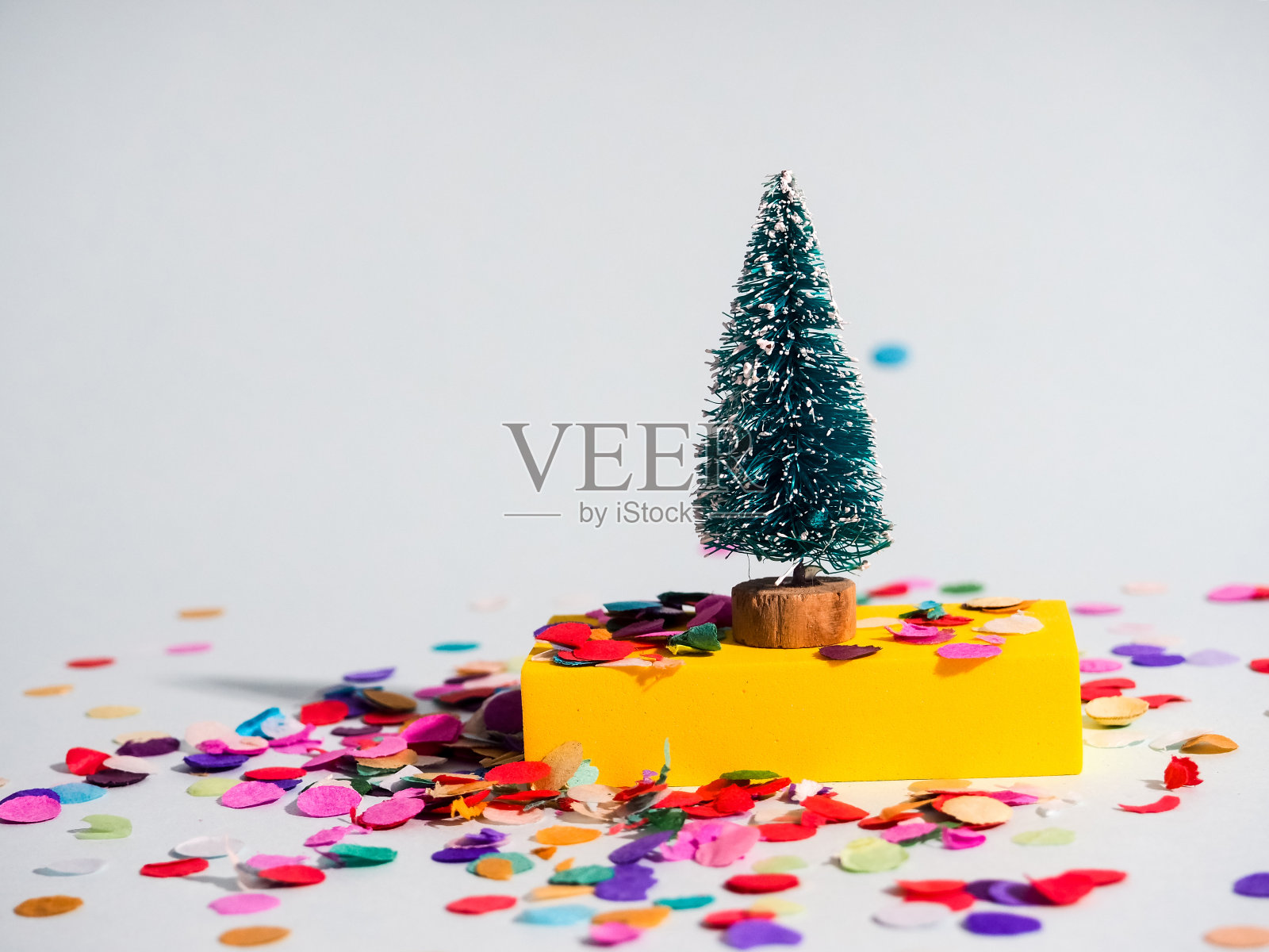 极简主义圣诞节，一棵圣诞树上的彩色背景与多色抽象数字，圣诞和新年的概念照片摄影图片