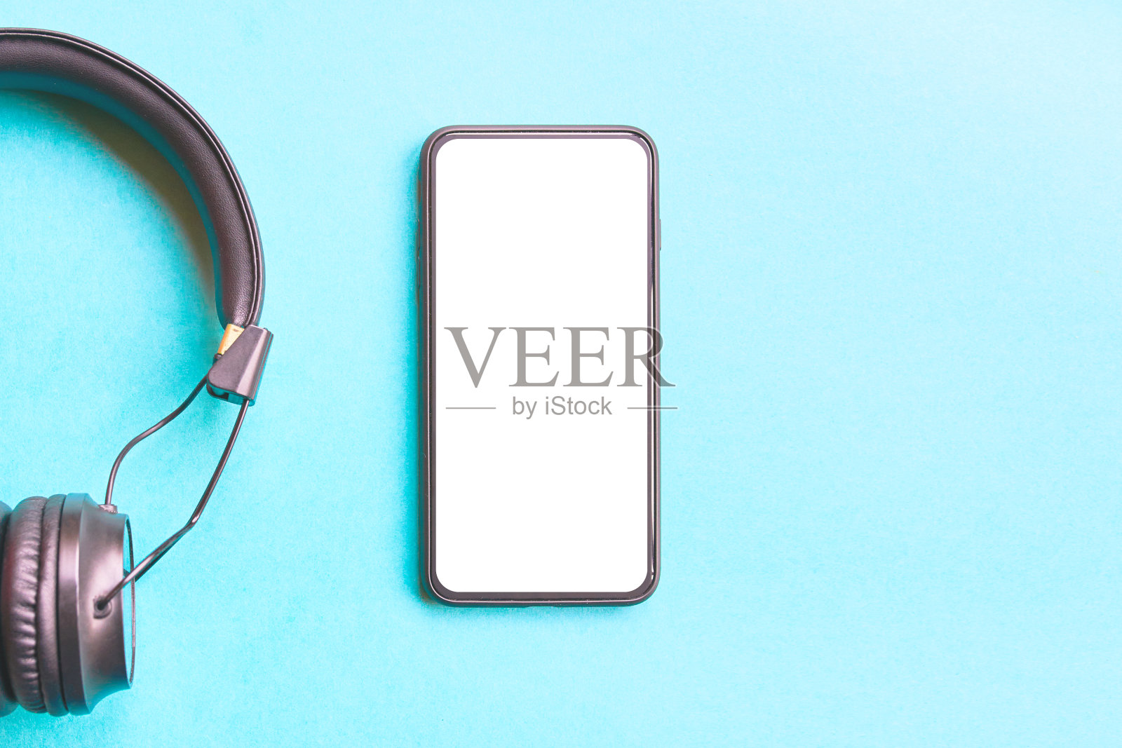 彩色背景上的耳机和智能手机。照片摄影图片