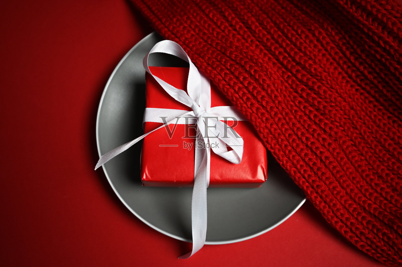 一份装在盘子里的礼物和一件毛衣照片摄影图片